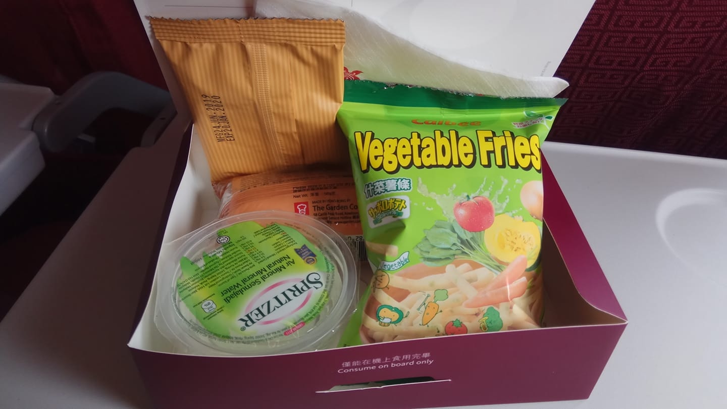 樓主本以為機上提供的餐點是常見的熱食飯餐,但今次竟然送上零食盒,內有餅乾、瑞士卷、薯條及一杯水,令他感到無奈。(fb群組「中伏飲食報料區」圖片)