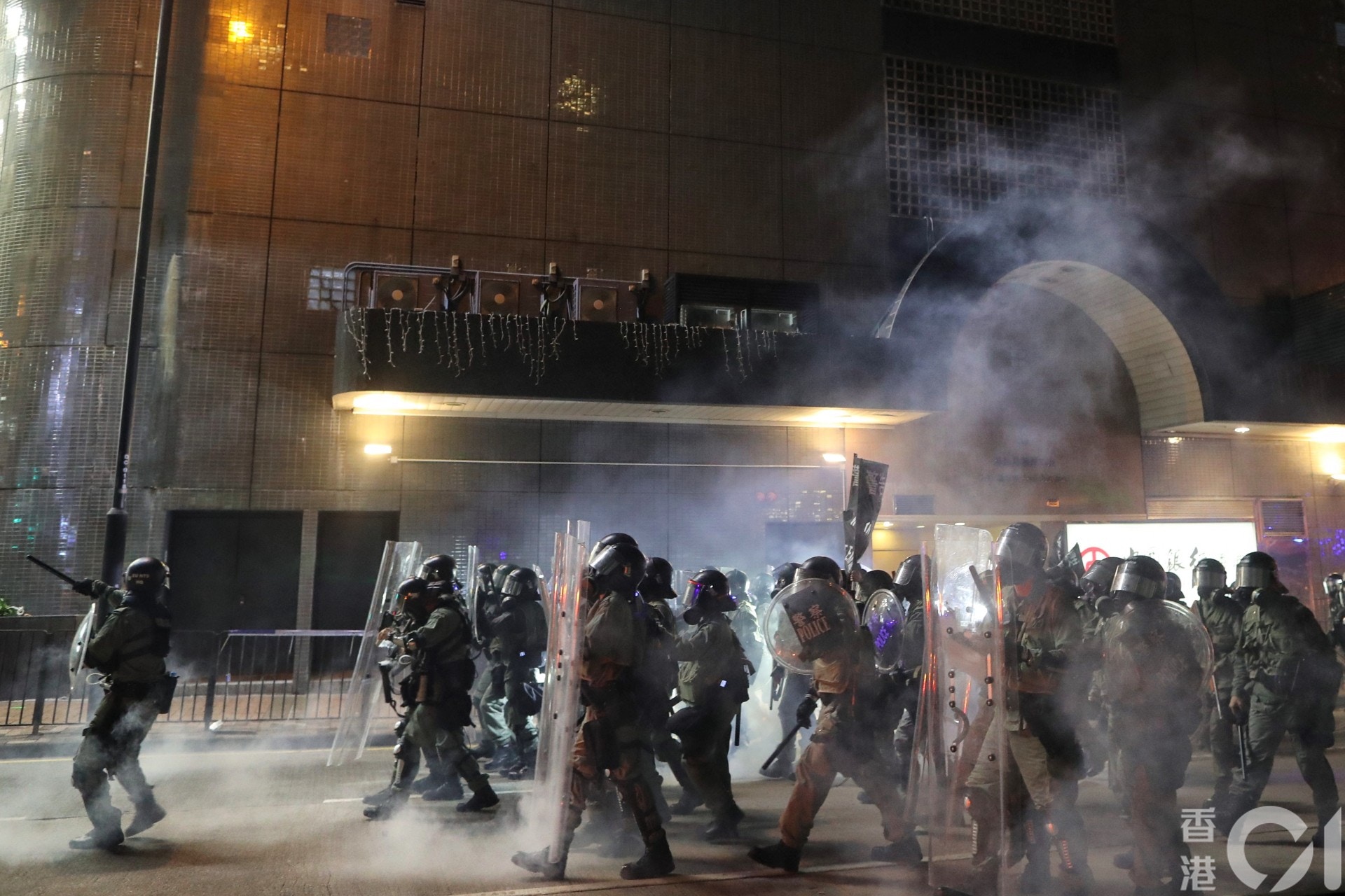 晚上約9時15分，有警察在催淚煙中前行。（曾梓洋攝）