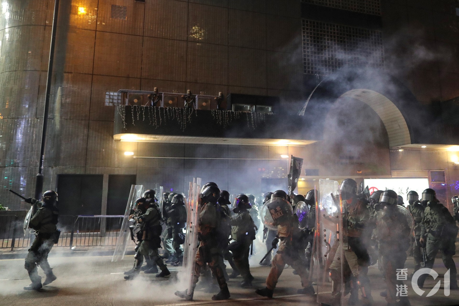 晚上約9時15分,有警察在催淚煙中前行。(曾梓洋攝)