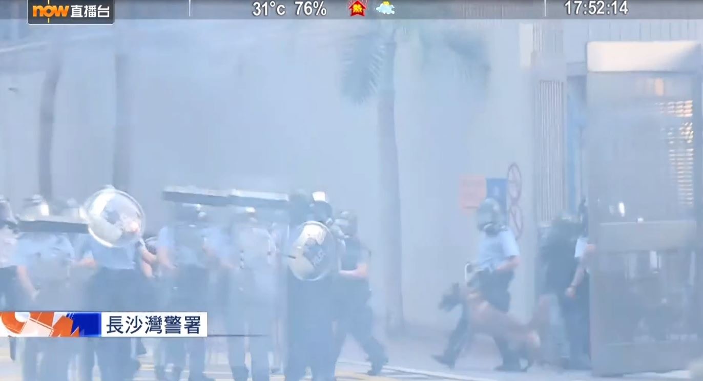 now早前（8月11日）下午拍攝到，有零裝備警犬被帶到煙霧迷漫的長沙灣警署外。（now直播台電視截圖）