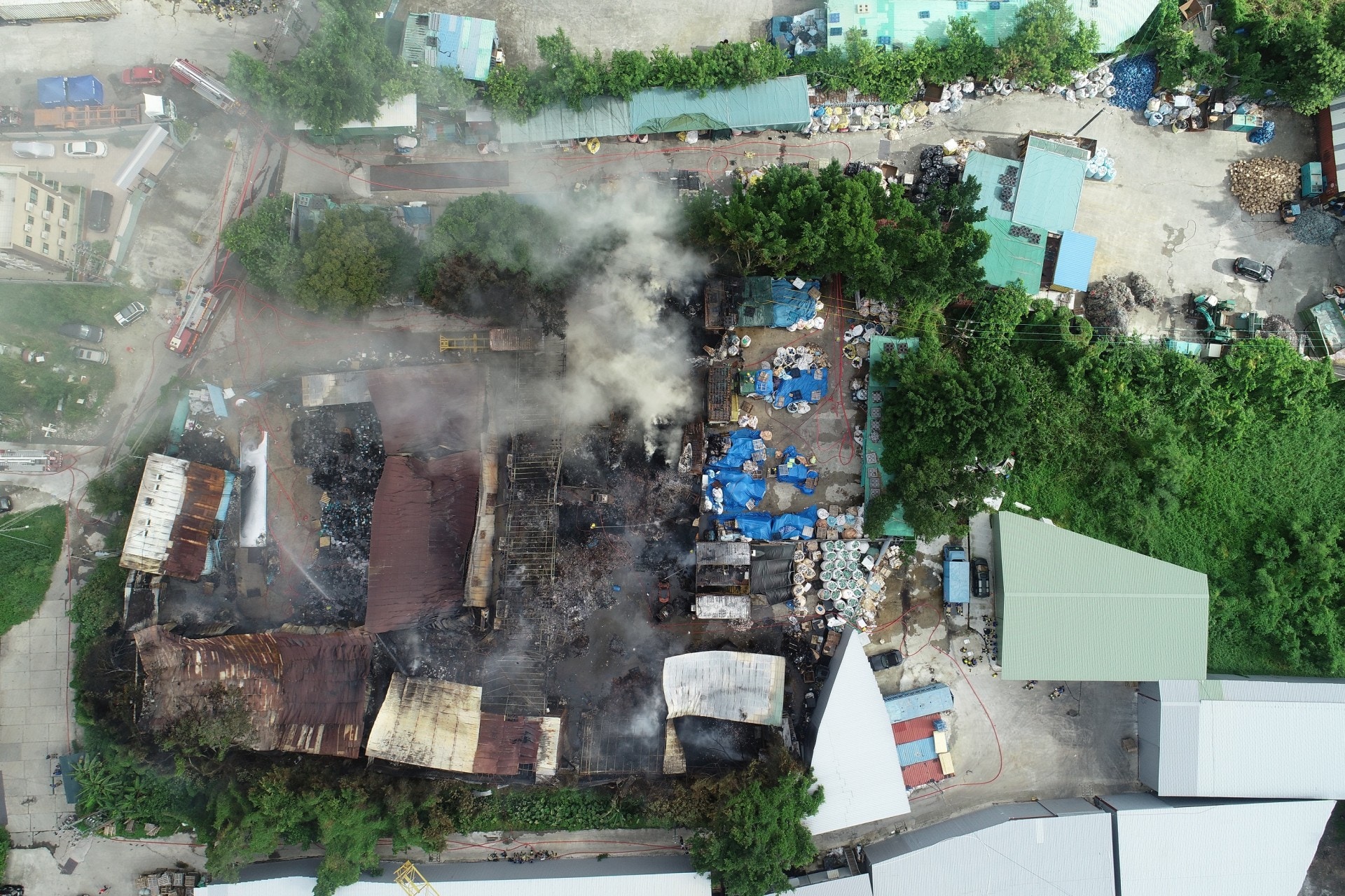火警發生位置鐵皮屋已薰黑，肇事位置仍見濃煙冒出。（黃偉民攝）