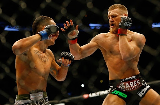 另一方面，Conor McGregor於2013年進入UFC。其實在進入UFC前，已有一眾評論員估計他能打出好成績，但應該沒人能想到他會成為如此的天王巨星，甚至變成圈外都為人熟知的拳手。圖中為2013年他於UFC的第二戰，當時他以判定擊敗Max Holloway，其時身上紋身也不多。（Getty Images）