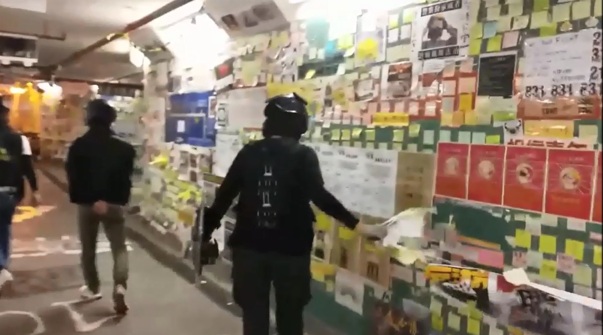 一名手持防暴盾的女警撕毀連儂隧道內右側牆身的海報,扭作一團。(區政聯盟大埔區議員區鎮樺片段截圖) 一名手持防暴盾的女警撕毀連儂隧道內右側牆身的海報,扭作一團。(區政聯盟大埔區議員區鎮樺片段截圖)