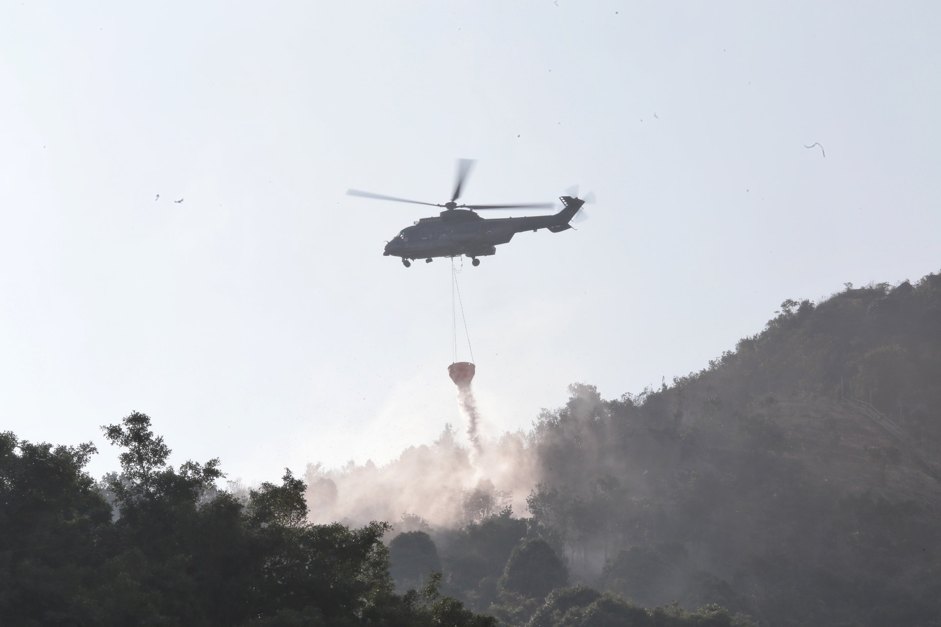 直升機繼續在山頭上空投擲水彈,以防山火死灰復燃。 (梁銘康攝) 直升機繼續在山頭上空投擲水彈,以防山火死灰復燃。 (梁銘康攝)