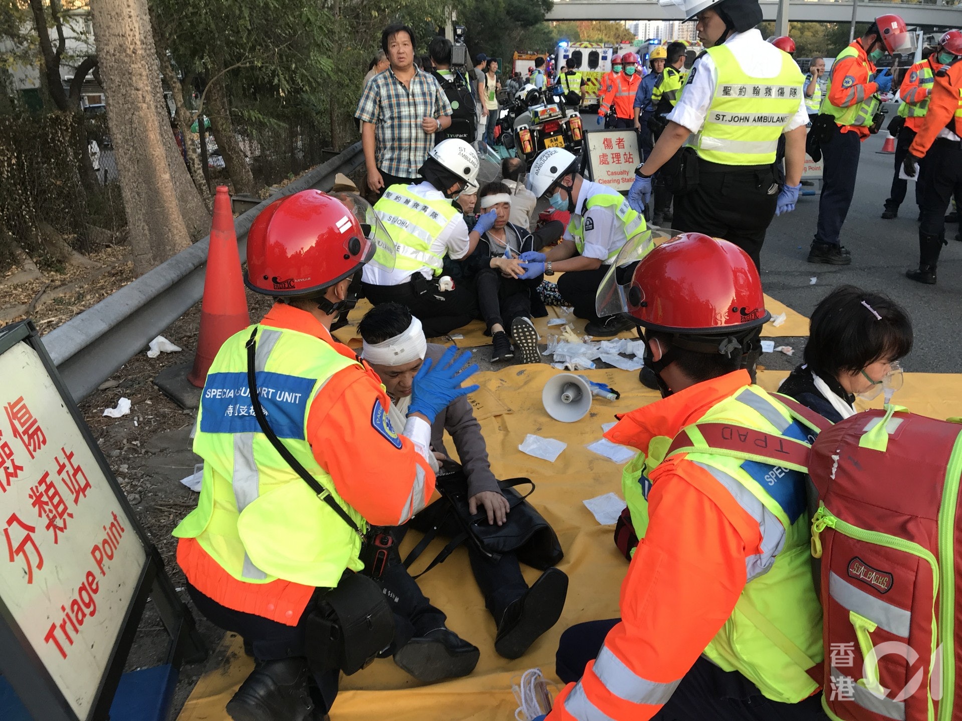 傷者坐在地上由救援人員協助包紮。(黃廸雯攝) 傷者坐在地上由救援人員協助包紮。(黃廸雯攝)