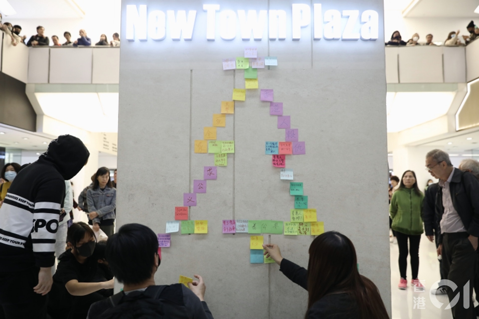 12月24日,沙田新城市廣場有大批戴上口罩的市民聚集,他們在牆上貼上寫有字句的便利貼,並砌成聖誕樹形狀。(盧翊銘攝) 12月24日,沙田新城市廣場有大批戴上口罩的市民聚集,他們在牆上貼上寫有字句的便利貼,並砌成聖誕樹形狀。(盧翊銘攝)