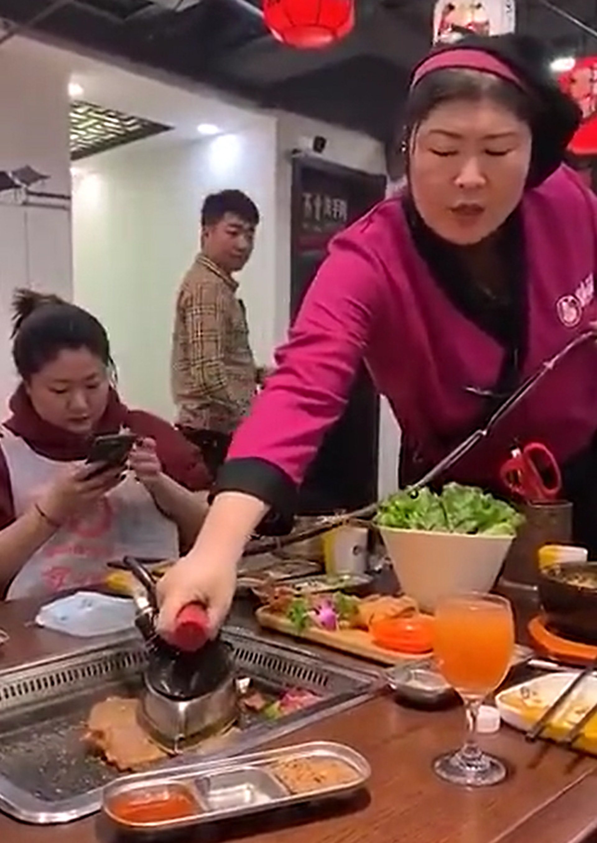 【內地餐廳奇趣錄#燒肉店出熨斗】2.大媽服務員的熨斗燒肉法,讓走過旁人卻忍不住偷看。(微博片段截圖) 【內地餐廳奇趣錄#燒肉店出熨斗】2.大媽服務員的熨斗燒肉法,讓走過旁人卻忍不住偷看。(微博片段截圖)
