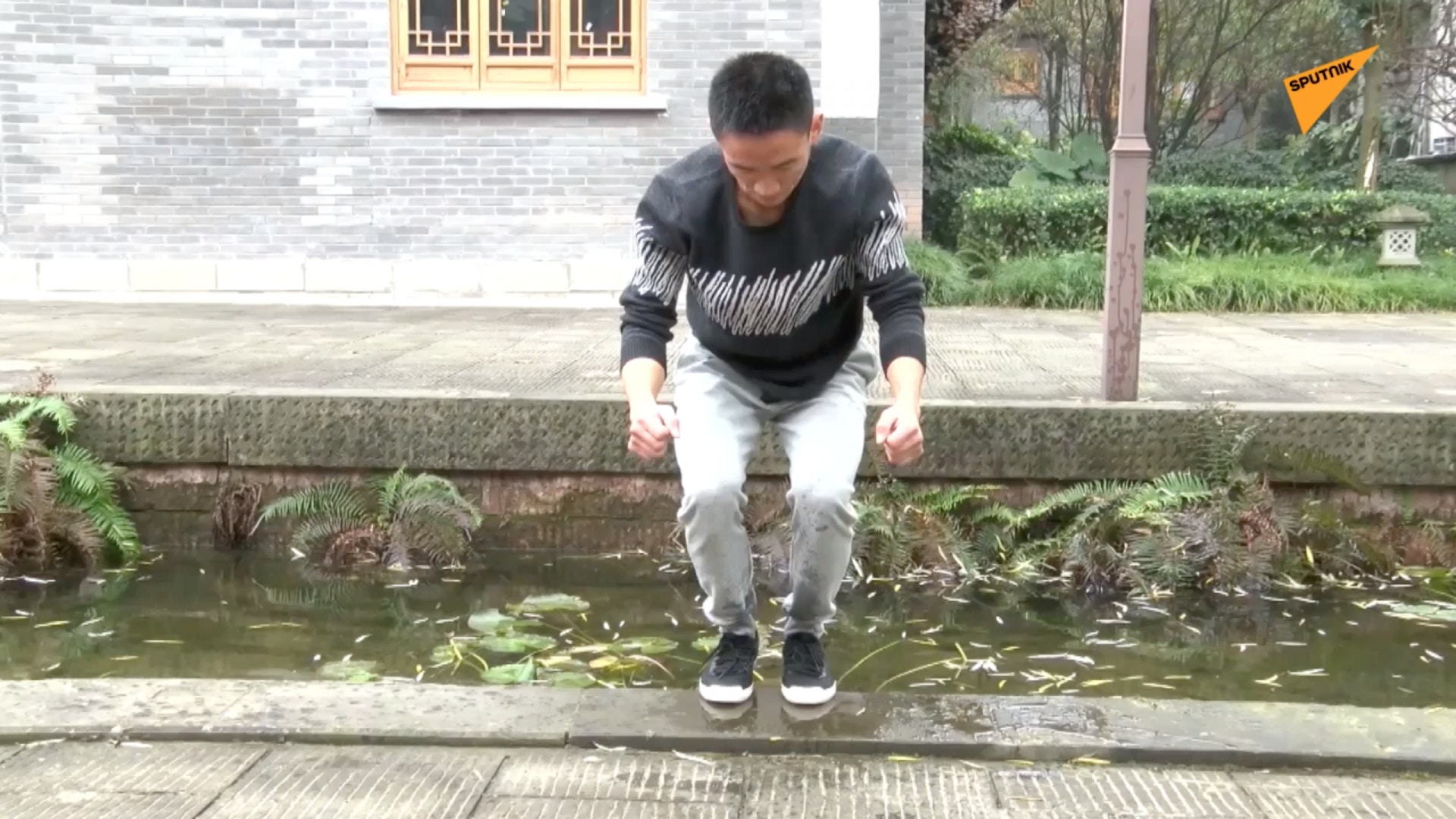 蹲在水邊。（影片擷取自：俄羅斯衛星通訊社）