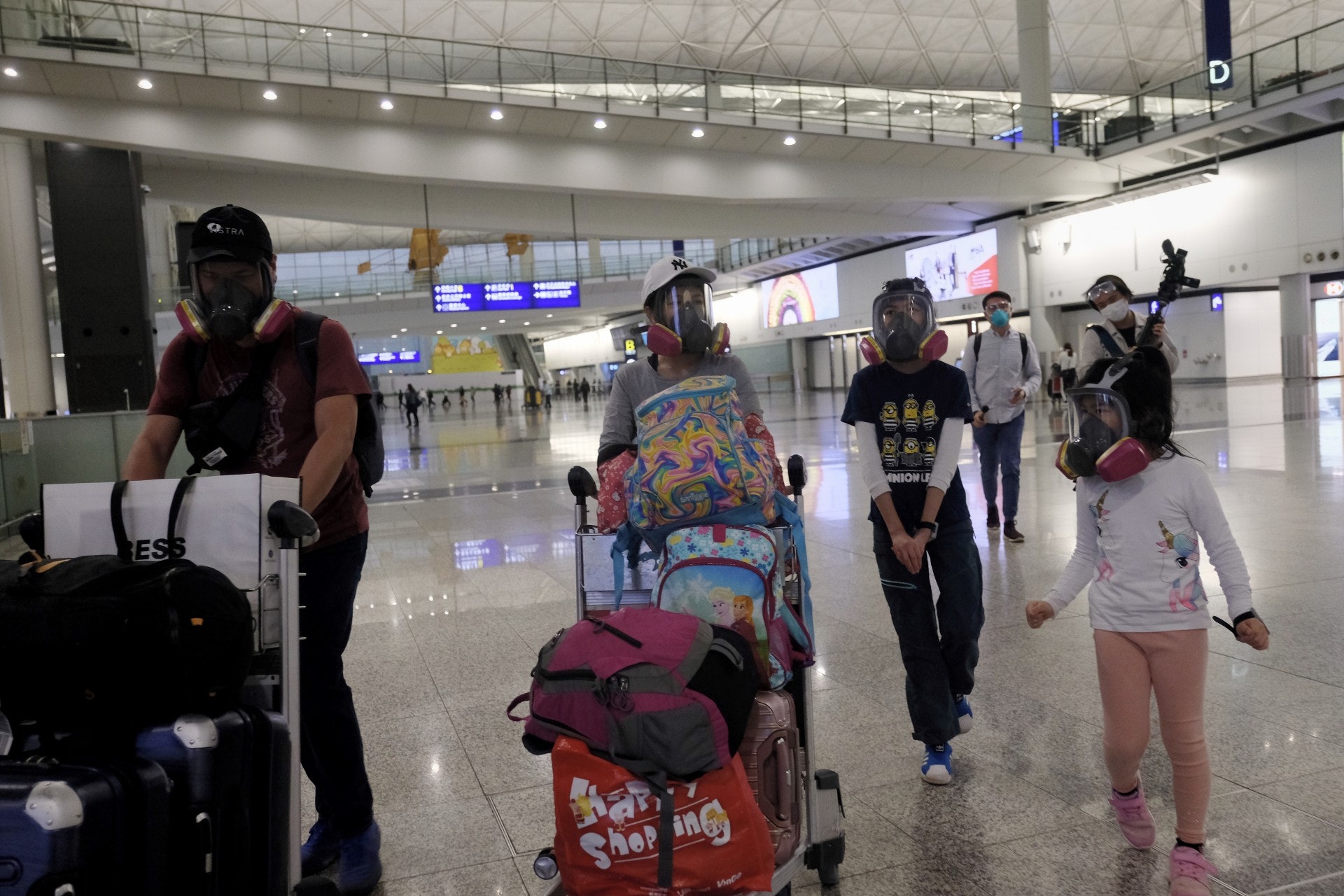 在英國乘坐飛機回港的何先生一家4口,連同2位10歲上下的女兒,全部戴住全面式3M面罩抵港。(歐嘉樂攝) 在英國乘坐飛機回港的何先生一家4口,連同2位10歲上下的女兒,全部戴住全面式3M面罩抵港。(歐嘉樂攝)