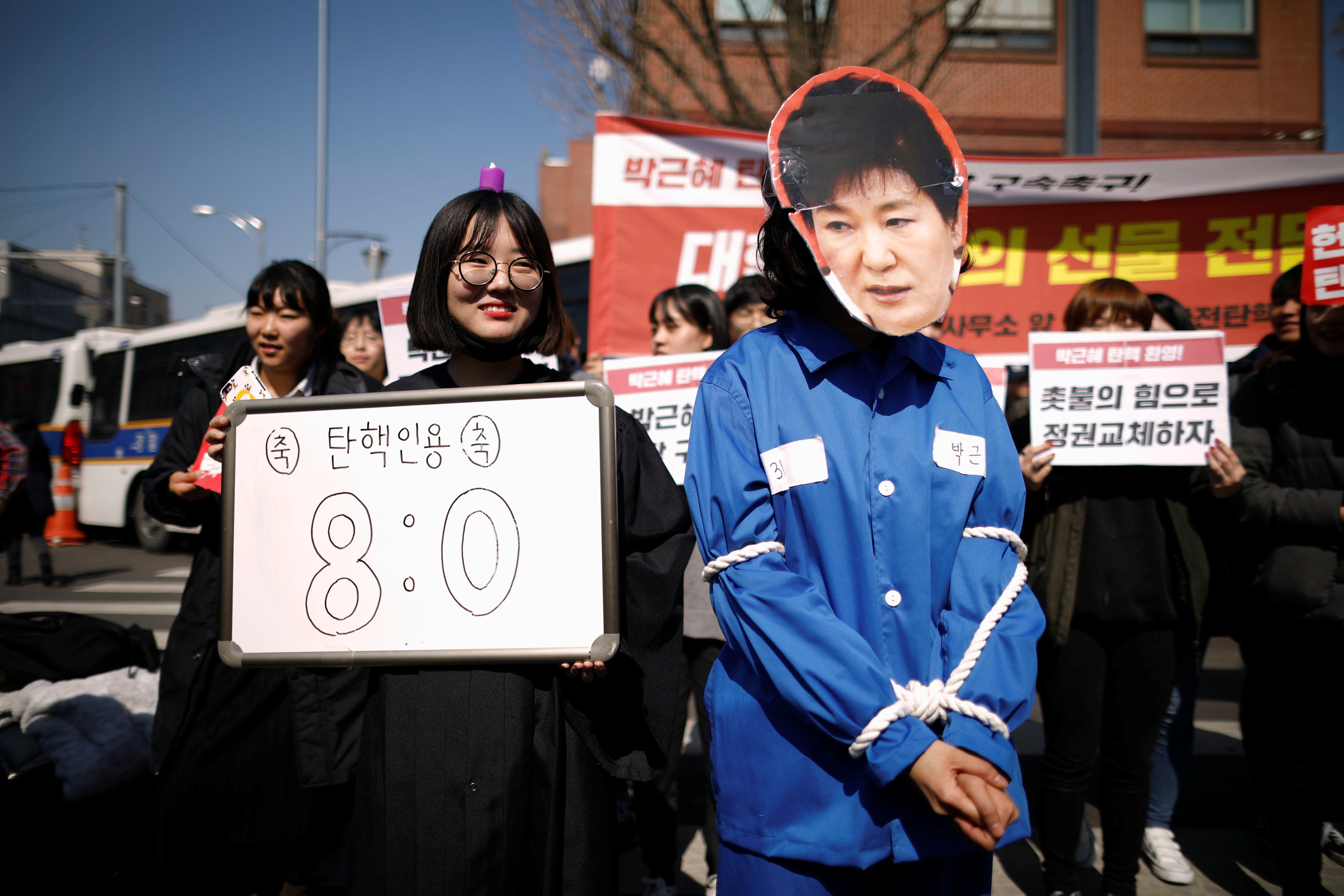 倒朴示威者高舉「8:0」的紙牌，指憲法法院8名法官一致贊成彈通遇。（路透社）