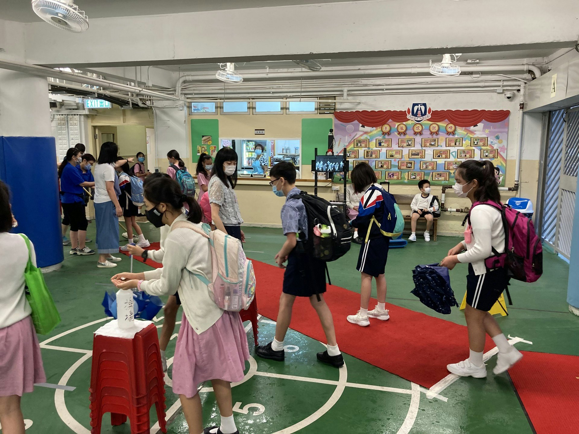 聖公會主風小學亦如常復課,學生進入校園時,必須行經消毒地氈及紅外線體溫探測,並須使用酒精搓手液消毒雙手。(鄺曉斌攝) 聖公會主風小學亦如常復課,學生進入校園時,必須行經消毒地氈及紅外線體溫探測,並須使用酒精搓手液消毒雙手。(鄺曉斌攝)