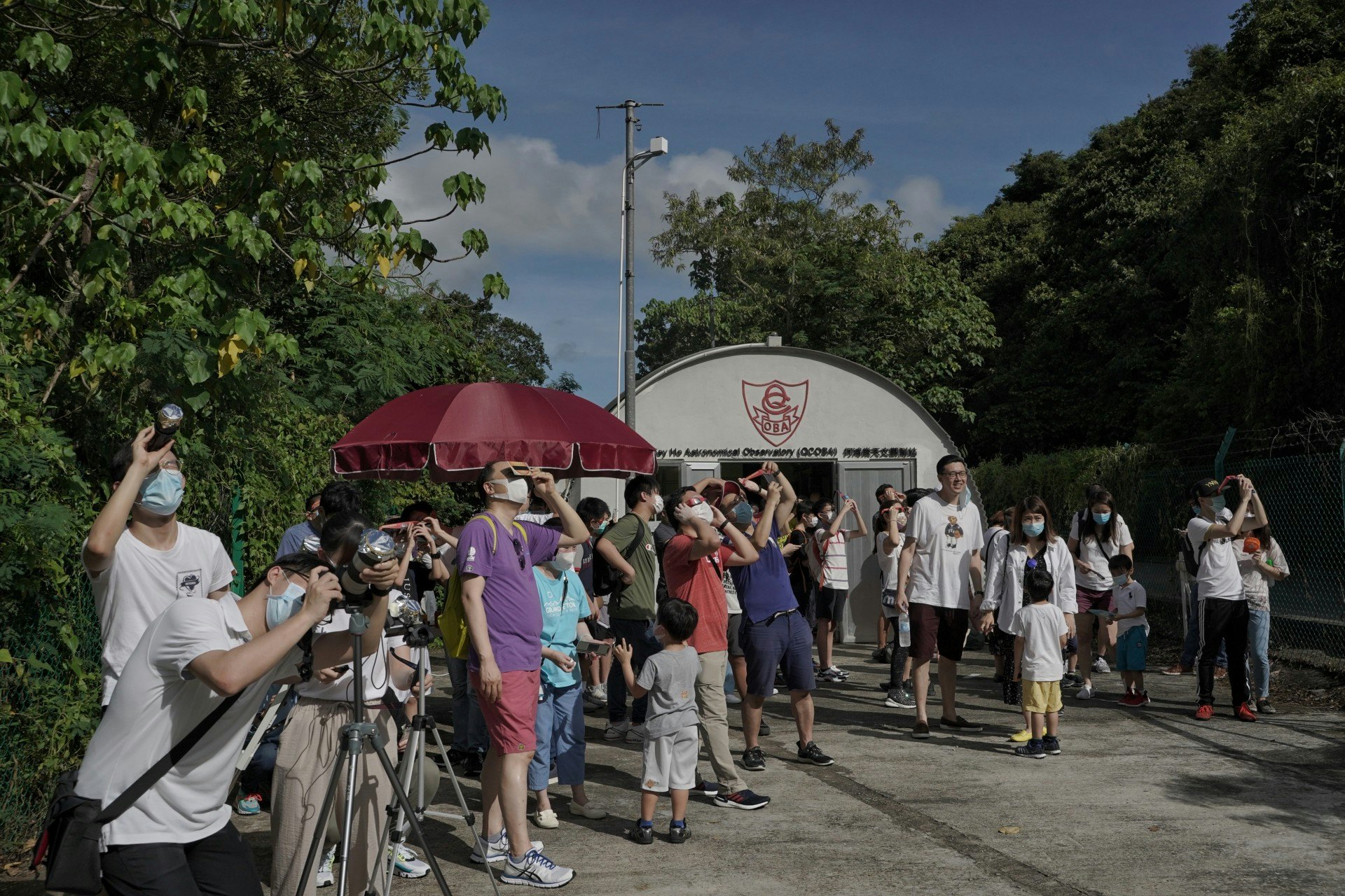 不少校友攜同一家大細參與活動,以特製的太陽濾鏡觀賞日食。(鄭子峰攝) 不少校友攜同一家大細參與活動,以特製的太陽濾鏡觀賞日食。(鄭子峰攝)