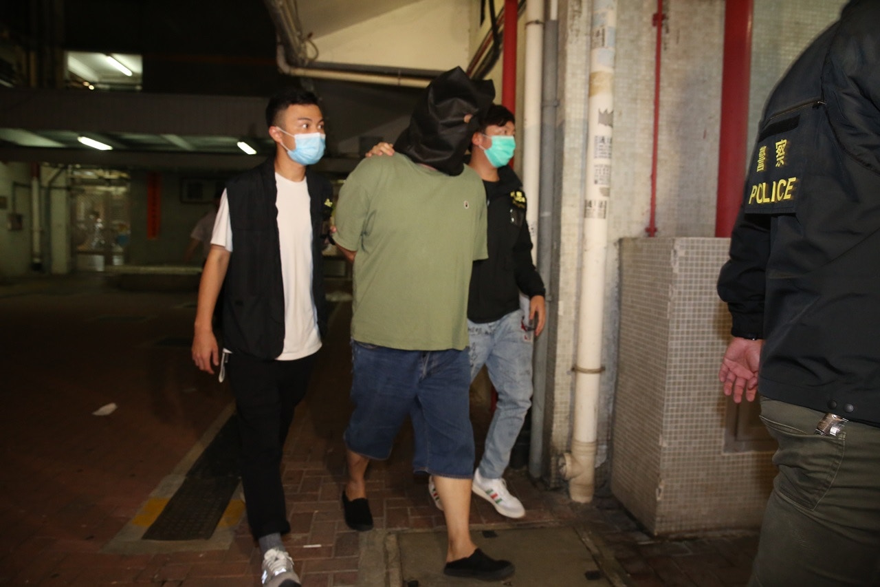 周六（25日）凌晨約零時，被捕男子遭黑布蒙頭，押至元朗朗屏邨繡屏樓搜證，逗留近20分鐘後離開。（陳永武攝）