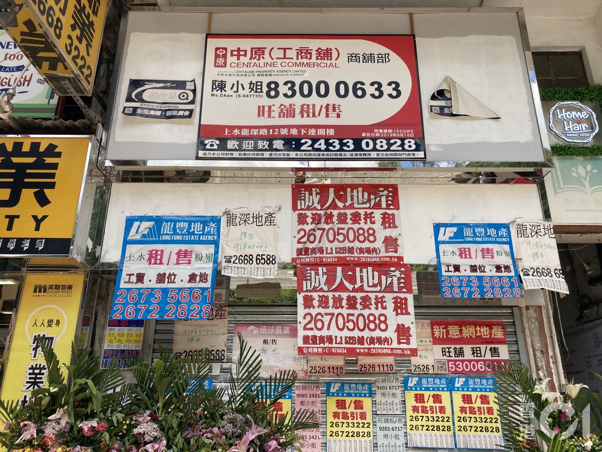 7月30日所見，上水街道上人流稀少，將近一半的藥房、化妝品店、兌換店已結業，亦有部分在鐵閘外貼上暫停營業的告示。（歐陽德浩攝）