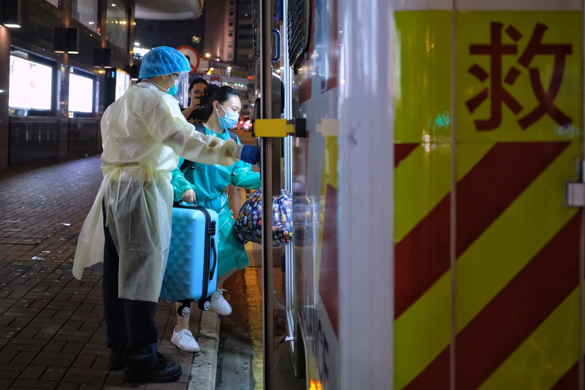 旺角維景酒店需檢疫住客及工作人員,晚上前往檢疫中心,一名女子則登上救護車。(羅君豪攝) 旺角維景酒店需檢疫住客及工作人員,晚上前往檢疫中心,一名女子則登上救護車。(羅君豪攝)