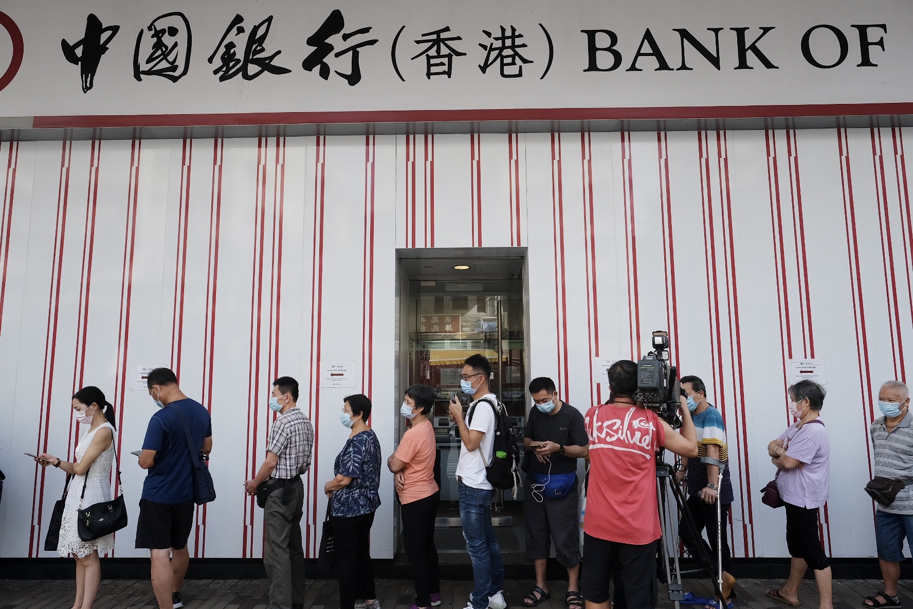 銀行開門前廿分鐘已有大約十人在等候，開門前一刻人龍大約有二十至三十人。（歐嘉樂攝）