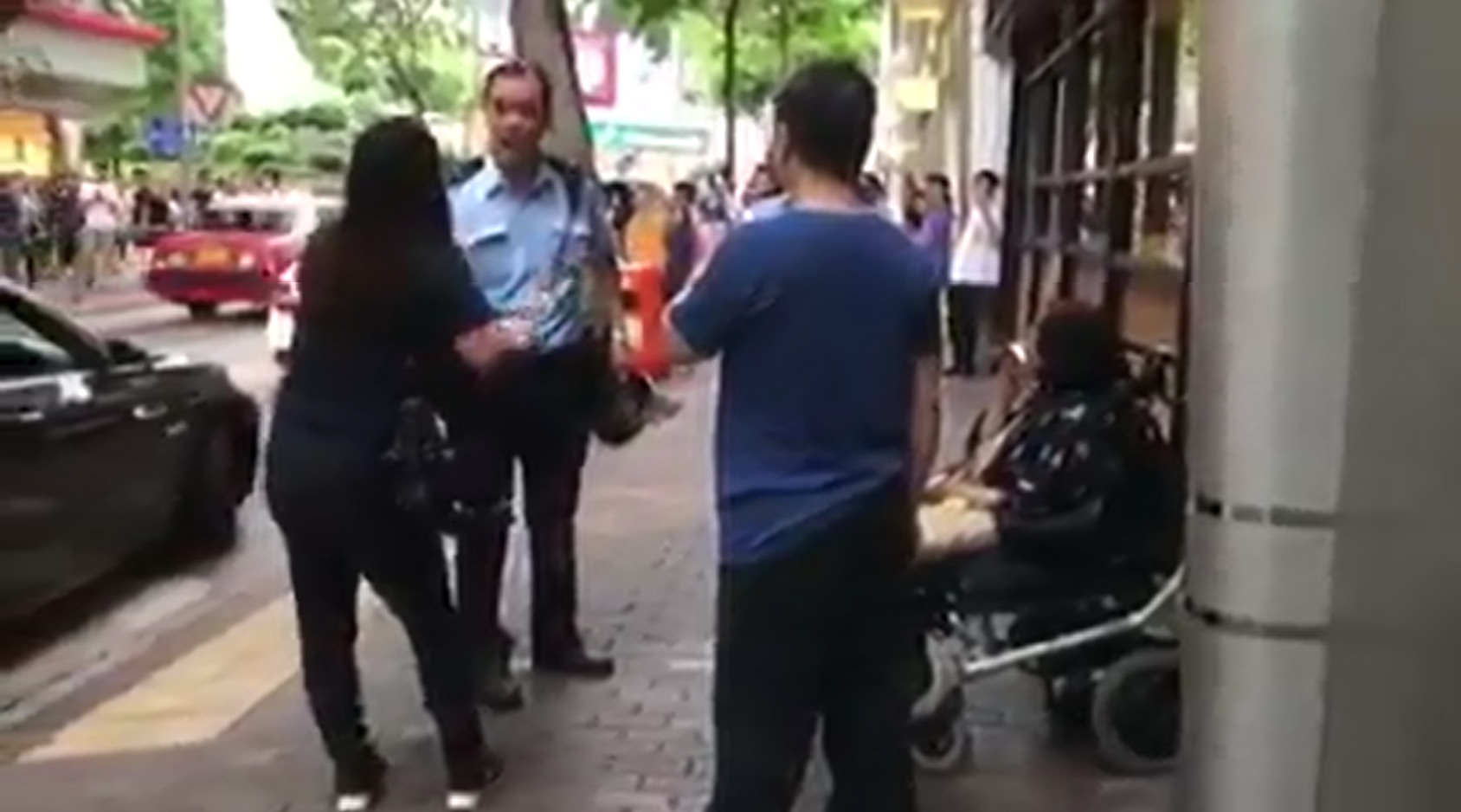 片段中司機（左三）及同行女友人（左一）不斷斥責警員，坐在輪椅的女士因私家車違泊而無法過路。（文人多說話fb群組片段截圖）
