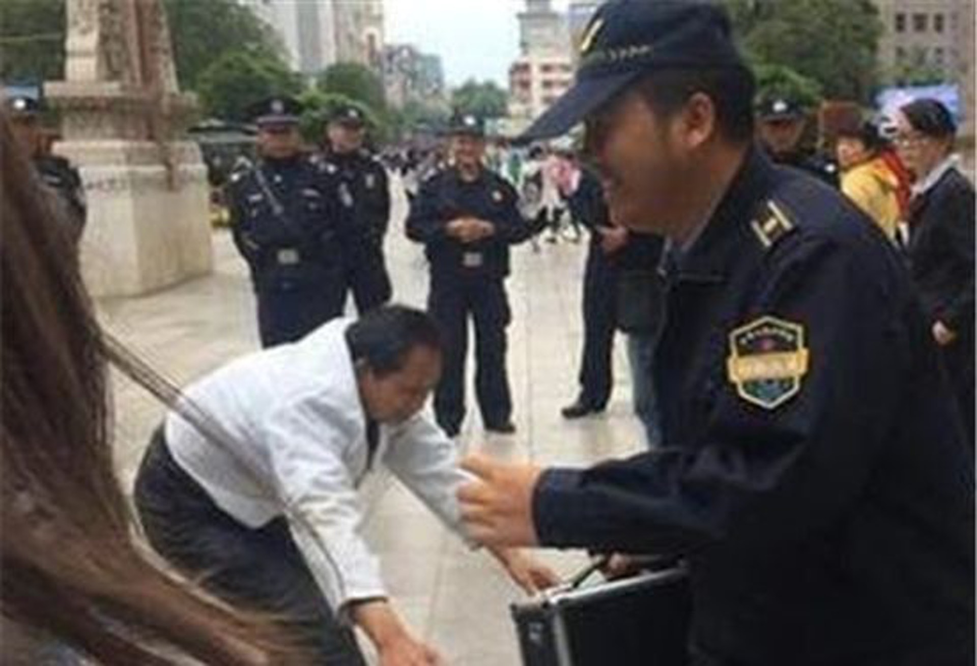 戲弄盲人的城管邊跑邊笑。(視頻截圖) 戲弄盲人的城管邊跑邊笑。(視頻截圖)