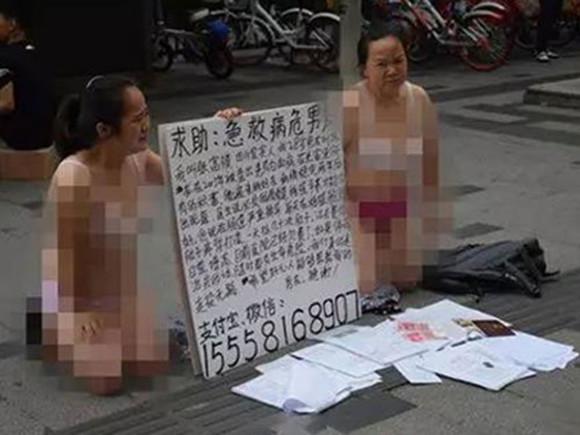 兩名女子僅穿內衣在鬧市跪地求助。(網上圖片) 兩名女子僅穿內衣在鬧市跪地求助。(網上圖片)