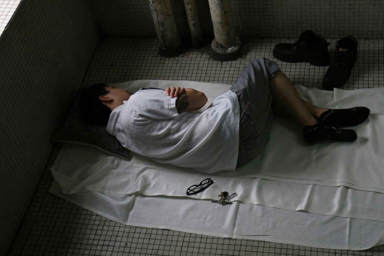 以地為蓆,以天為被,廚師落場無處容身,瑟縮於後樓梯。(蔡正邦攝) 以地為蓆,以天為被,廚師落場無處容身,瑟縮於後樓梯。(蔡正邦攝)