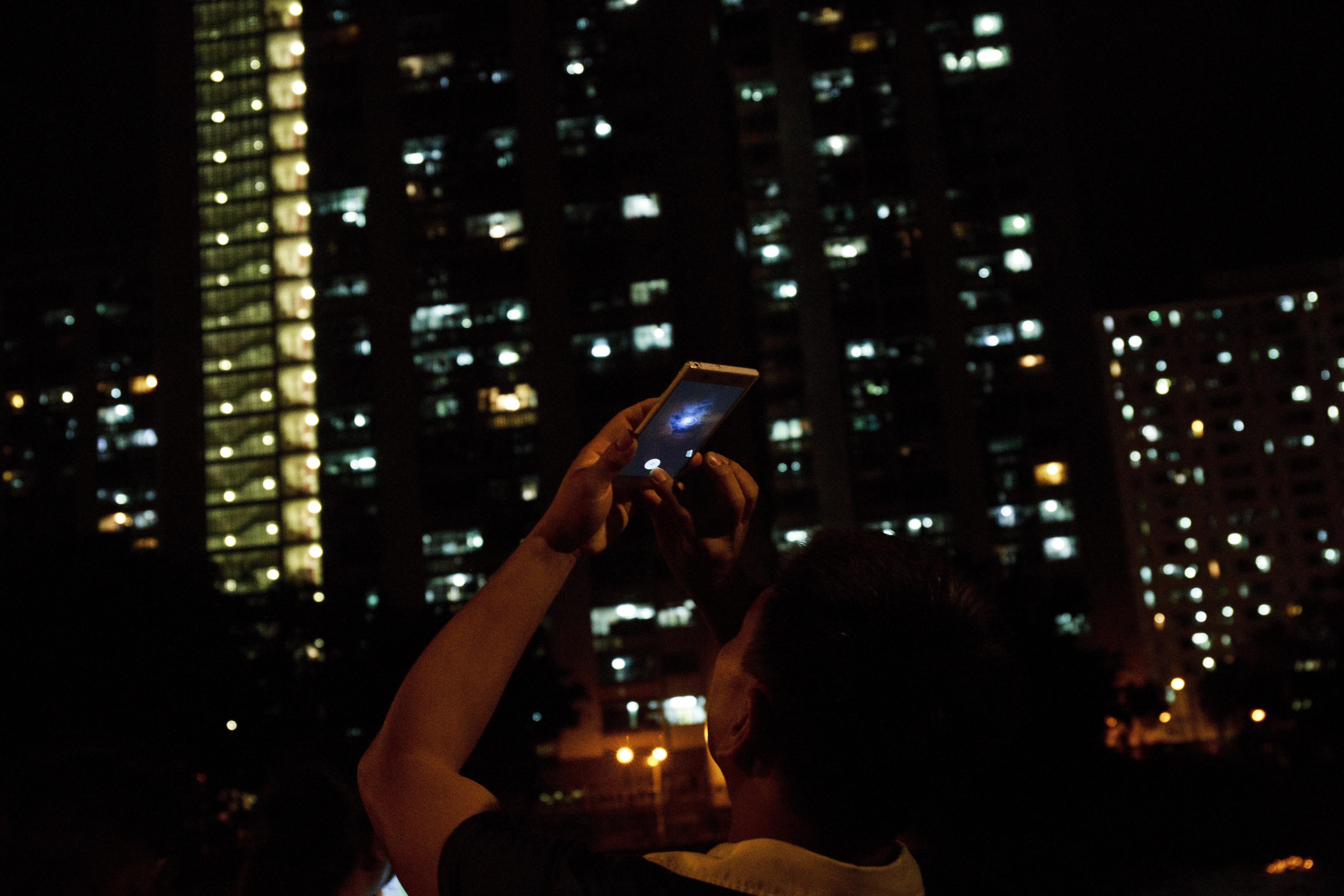 途人以電話拍攝月亮照片。