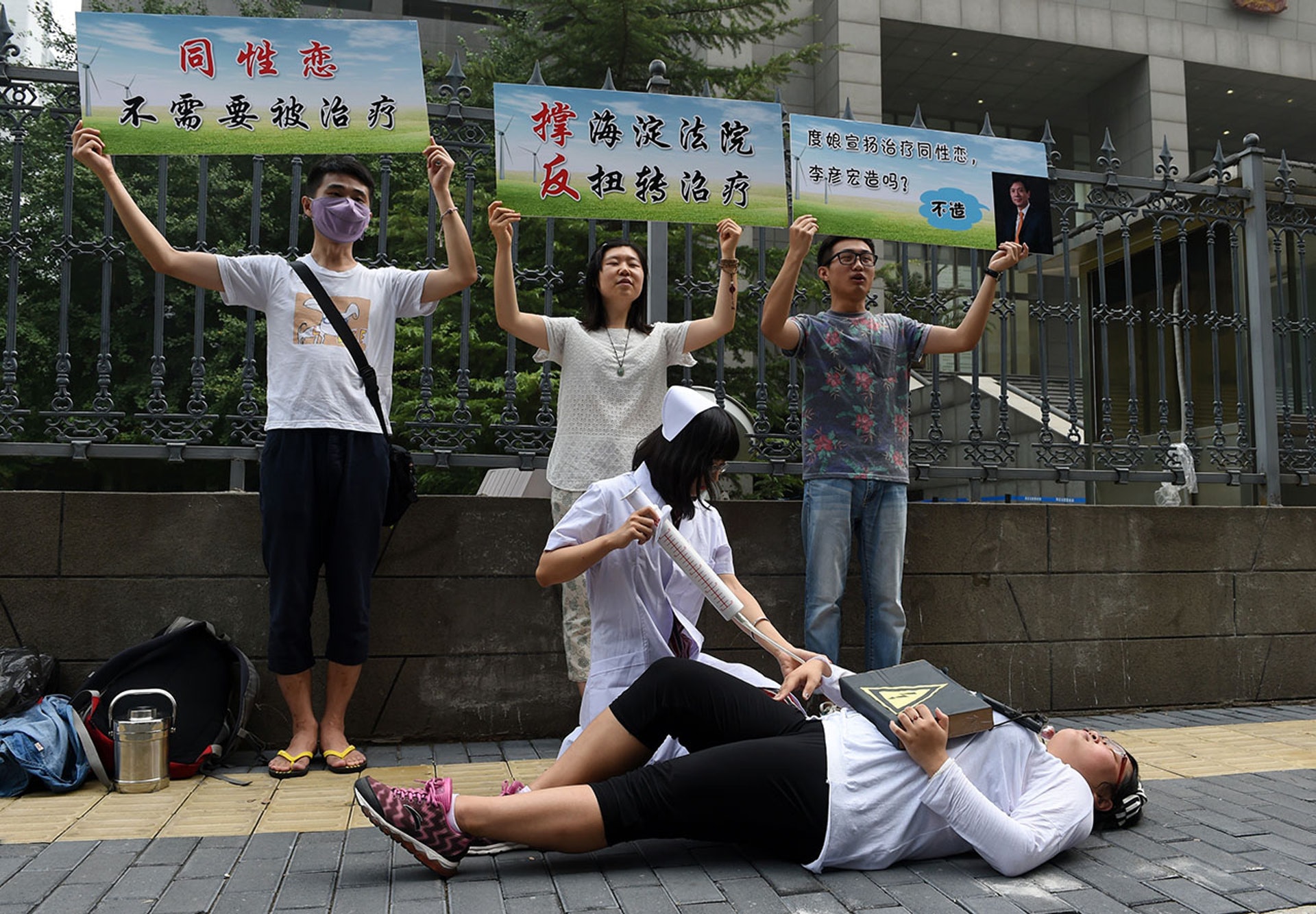 2014年內地首宗拗直治療案在北京海澱區法院開審，有團體在庭外抗議，指同性戀並非精神病，毋須被治療。案件最後判決拗直治療機構敗訴。（法新社 / Getty Images）