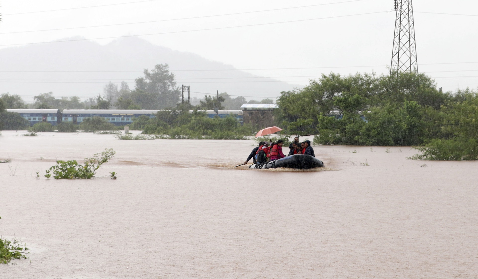 印度豪雨引發洪水,導致一輛載有逾千人的火車7月25日受困,圖為乘客搭橡皮艇離開。(AP) 印度豪雨引發洪水,導致一輛載有逾千人的火車7月25日受困,圖為乘客搭橡皮艇離開。(AP)