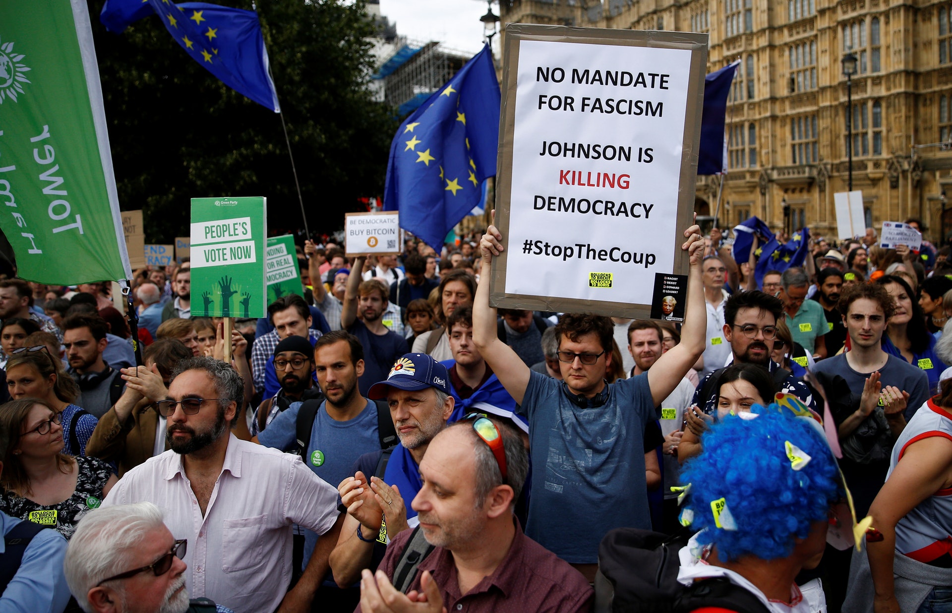 有民眾手持標語,指約翰遜的手段扼殺民主。(Reuters)