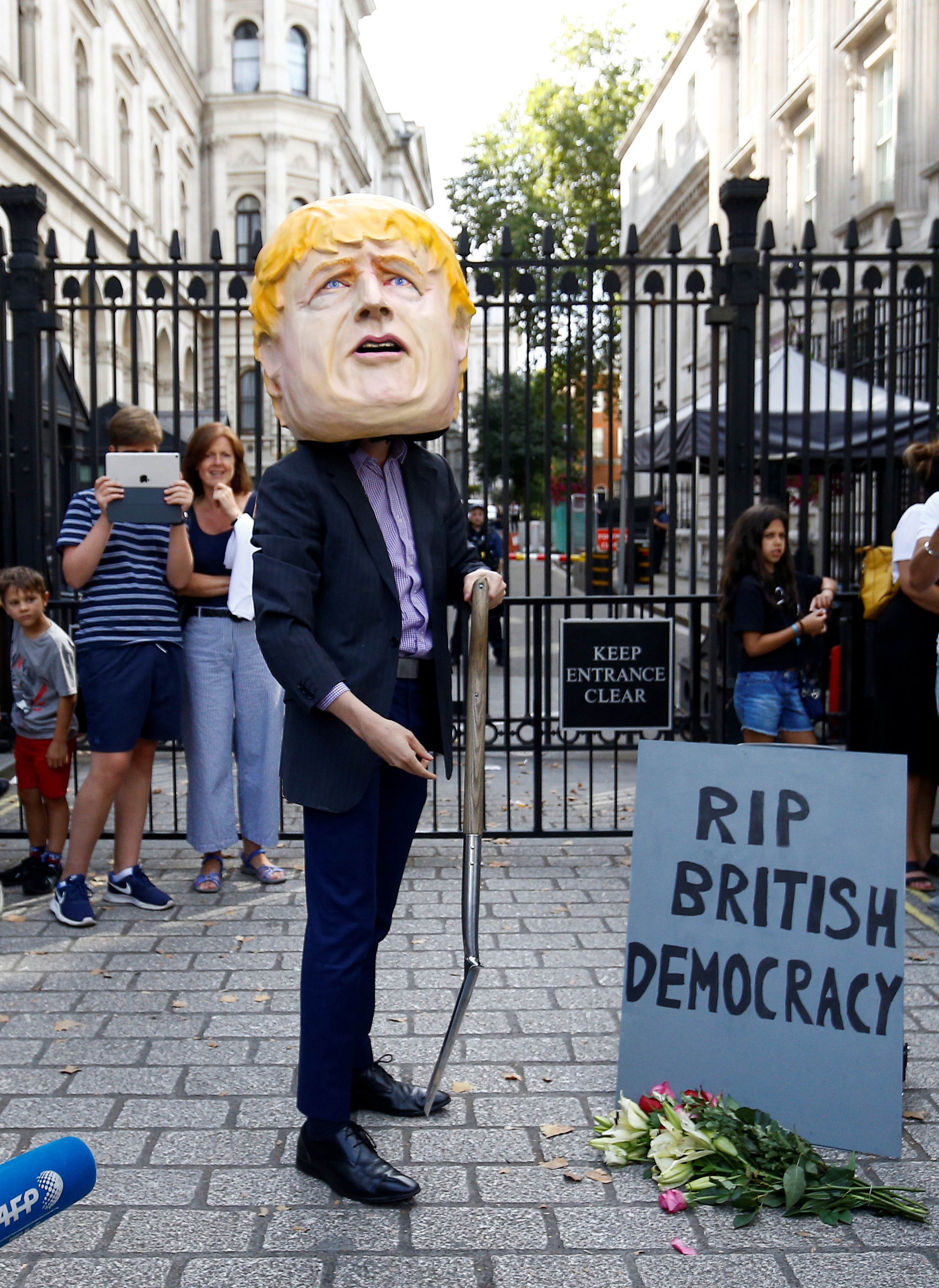 英國脱歐：有民眾戴上首相約翰遜的面具，在倫敦唐寧街首相府外示威，抗議對方一手埋葬英國民主。（路透社）