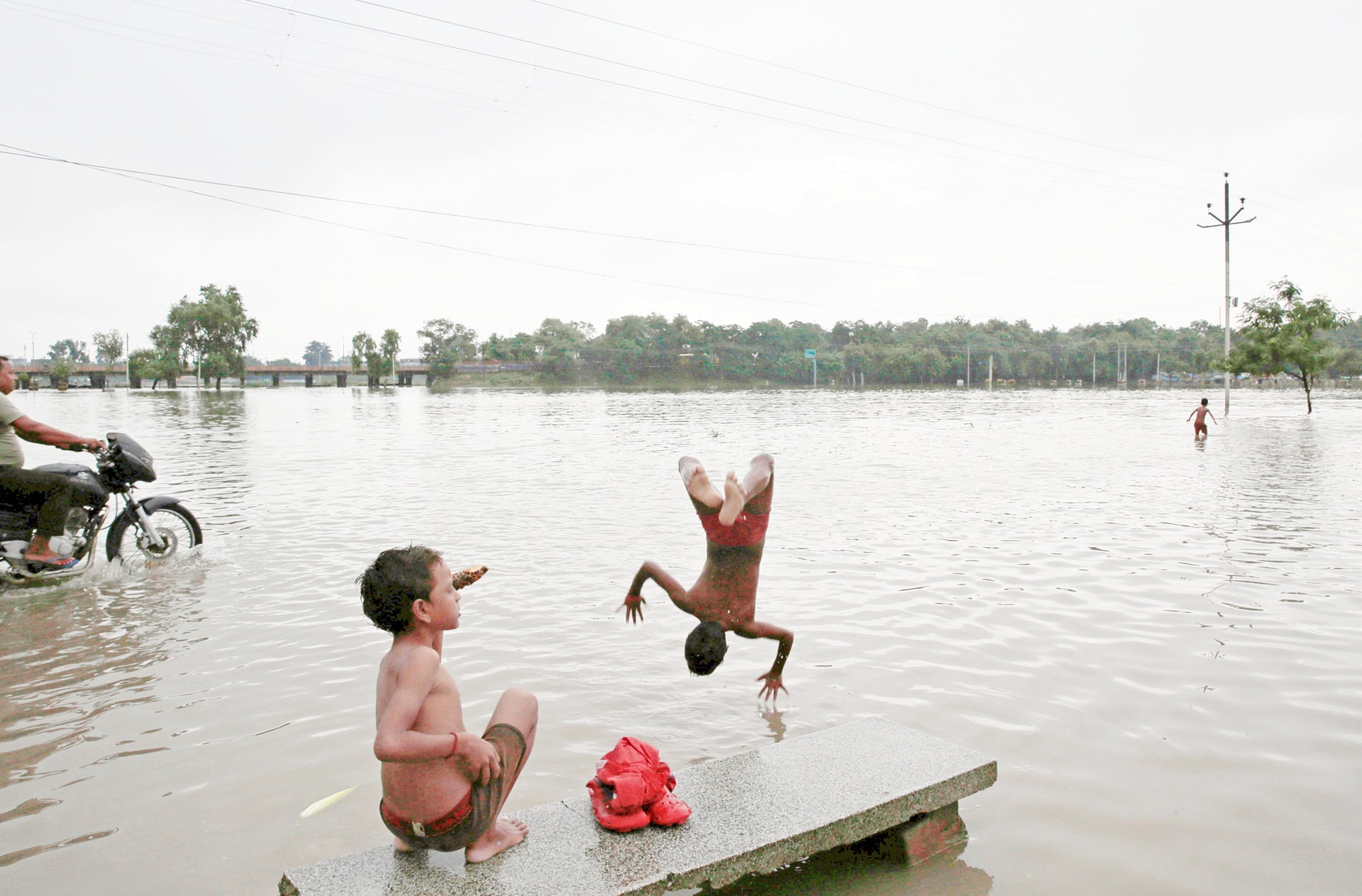 印度暴雨:圖為9月28日,北方邦普拉亞格拉傑市有小朋友跳入洪水中玩耍。(AP) 印度暴雨:圖為9月28日,北方邦普拉亞格拉傑市有小朋友跳入洪水中玩耍。(AP)