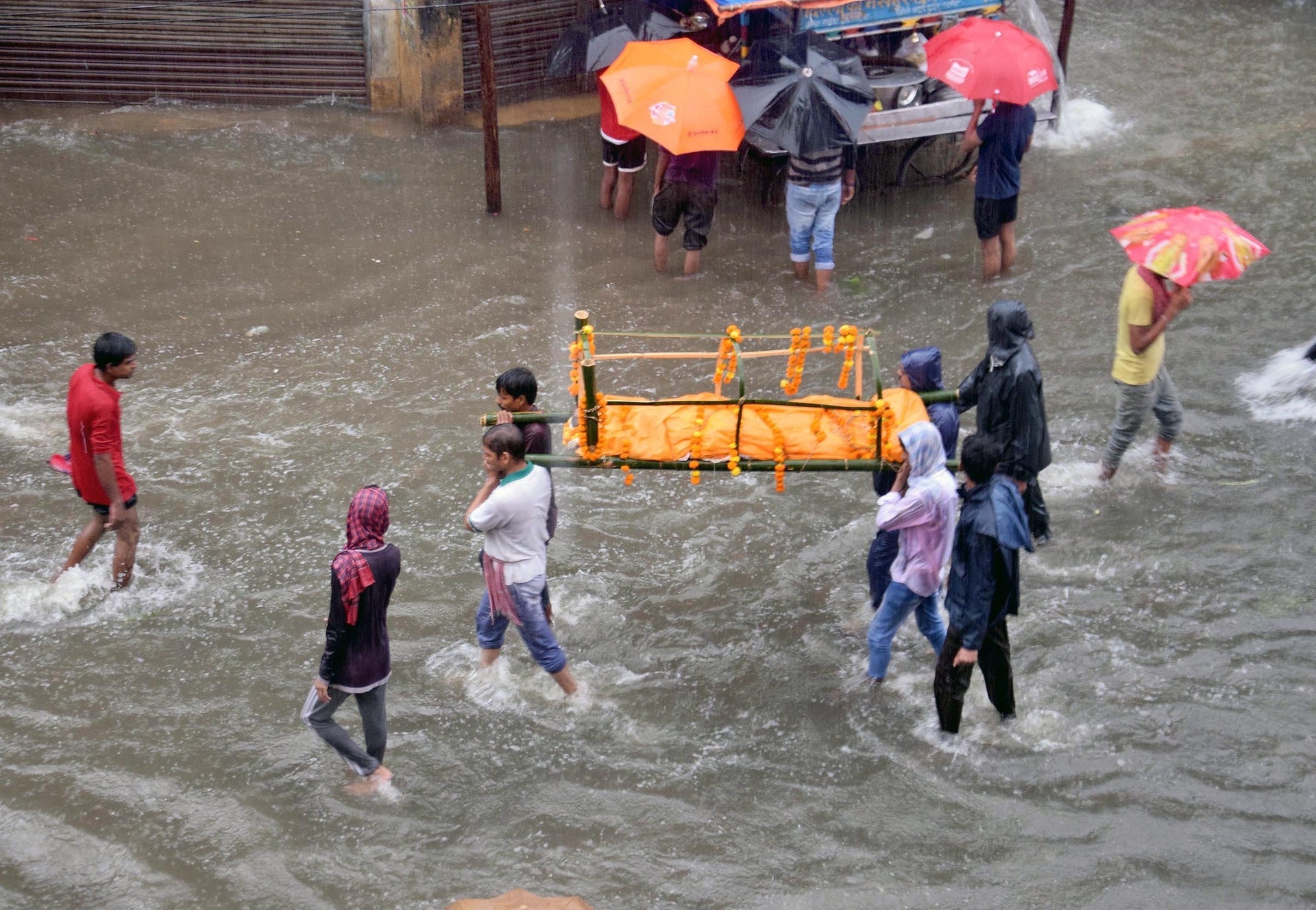 印度暴雨:巴特那市的居民9月28日在洪水走過,為死者送殯。(VCG)