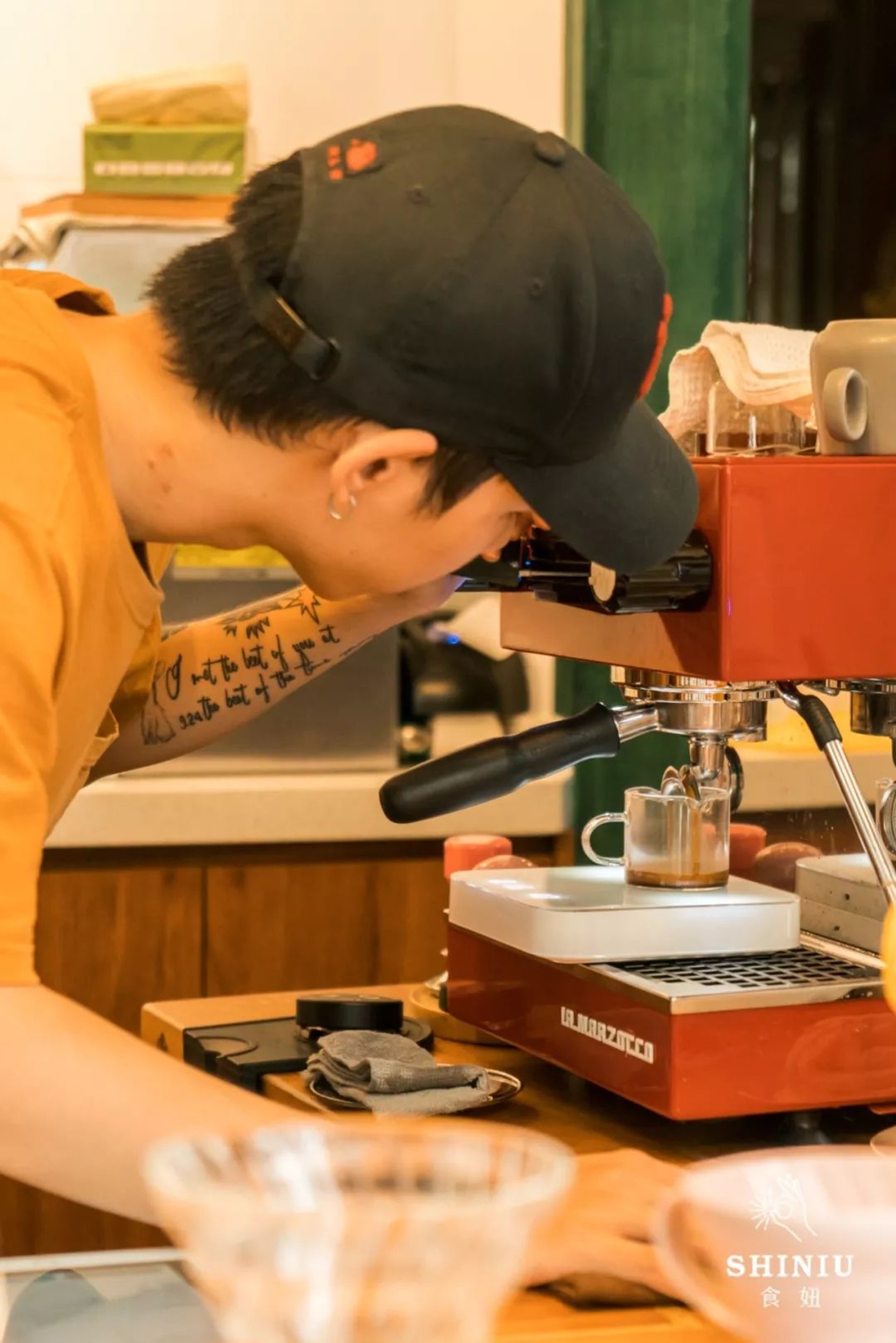【Cappuccino與Latte】年輕帥氣的男咖啡師在機器間忙碌,手肘上似乎是紋了一段經文(食妞授權使用) (食妞授權使用)