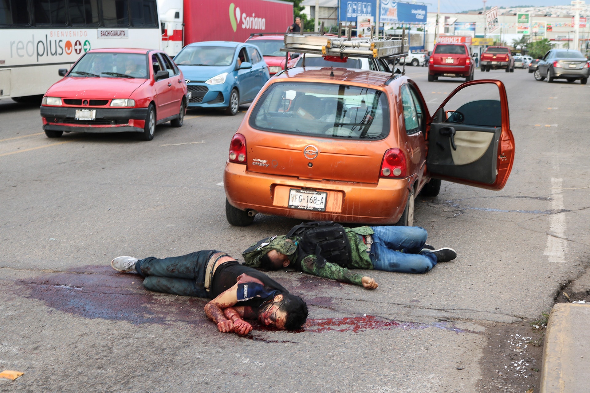 販毒集團的武裝份子與軍警爆發激烈槍戰,有屍體倒在汽車旁邊。(路透社) 販毒集團的武裝份子與軍警爆發激烈槍戰,有屍體倒在汽車旁邊。(路透社)