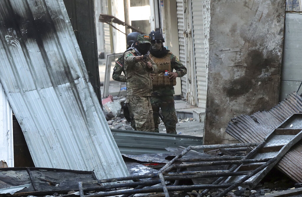 伊拉克示威：11月30日，有警員用丫叉將石頭射向示威者。（AP）