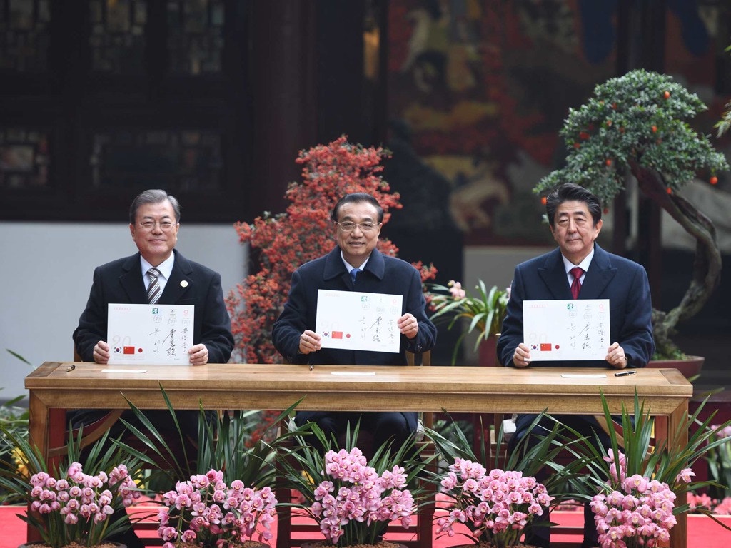 2019年12月24日，中國國務院總理李克強（中）在四川成都杜甫草堂博物館與韓國總統文在寅（左）、日本首相安倍晉三（右）共同出席中日韓合作20周年紀念活動。圖為三國領導人共同出席「中日韓合作20周年紀念封」發行儀式。（新華社）