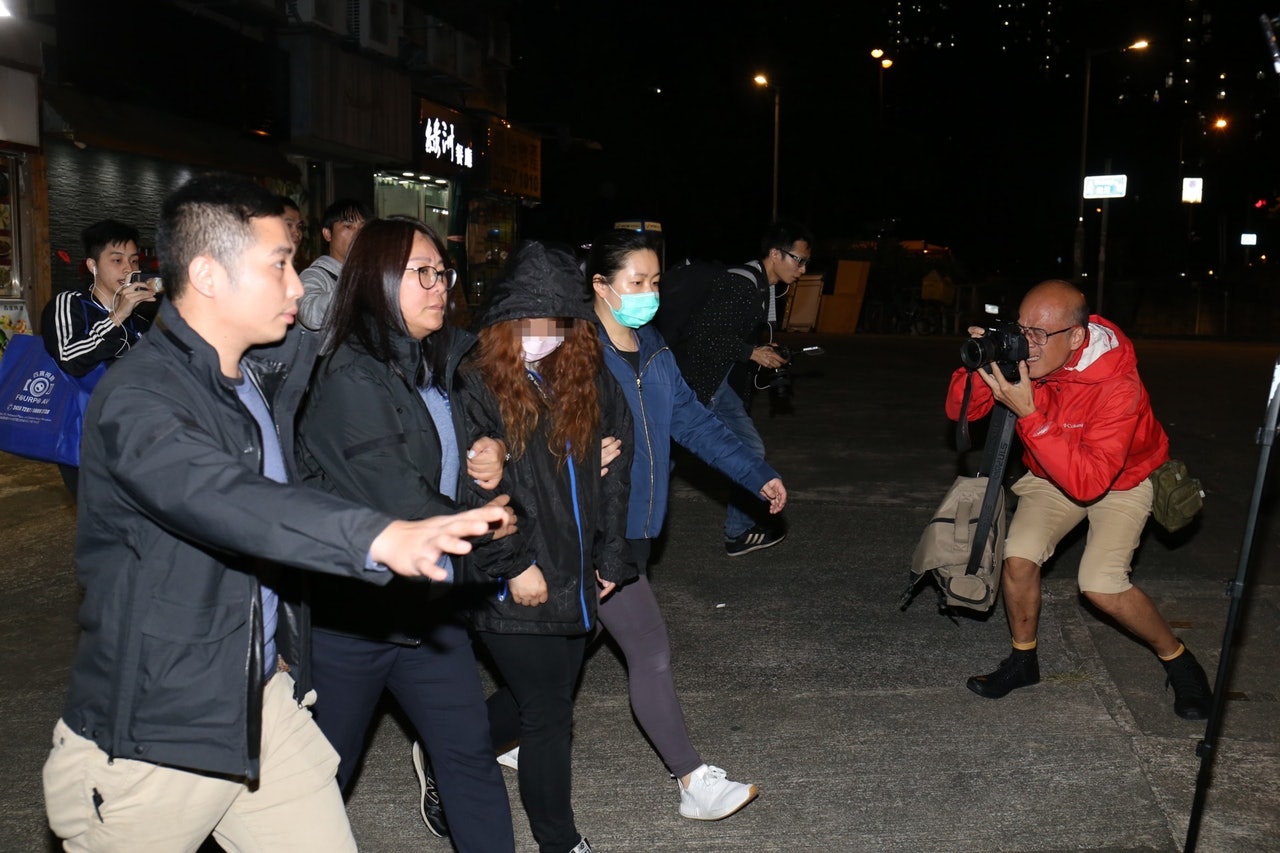 大埔寵物店虐狗案,涉案28歲寵物店女負責人(粉紅色口罩者)被捕,帶署扣查。(陳浩然攝) 大埔寵物店虐狗案,涉案28歲寵物店女負責人(粉紅色口罩者)被捕,帶署扣查。(陳浩然攝)