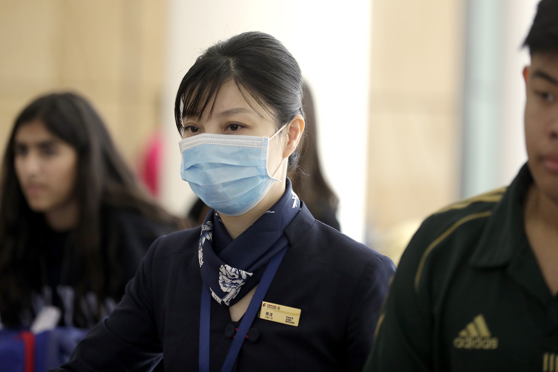 一班從武漢出發的航班抵達澳洲悉尼，機艙服務員也戴上口罩。（美聯社）