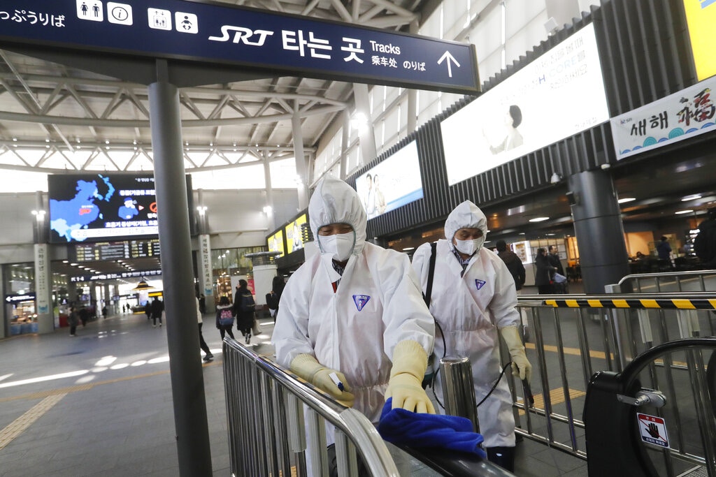 图为1月24日工作人员在韩国首尔水西站清洁栏杆，加强预防病毒传播。（AP）