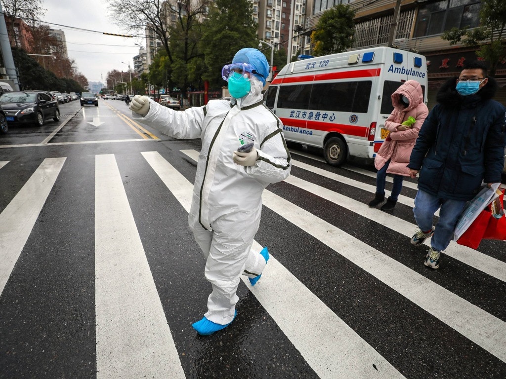 2020年1月26日，中国湖北省武汉市一名身穿防护服的医护人员带领病人前往一家医院。（AP）