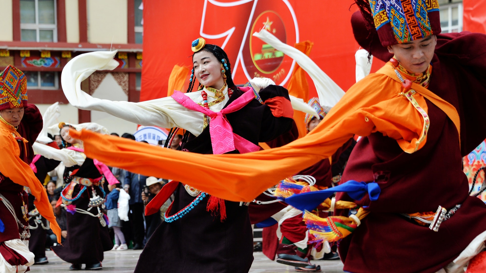 一直沒有確診個案的西藏自治區亦出現第一個確診個案。這代表中國31個省市區已是全部都有確診個案。圖為2019年8月20日西藏自治區昌都一個文化慶祝活動中,身穿藏族服飾的舞蹈員在一個印有慶祝中國建國70周年字樣的標誌前跳舞。(Reuters) 一直沒有確診個案的西藏自治區亦出現第一個確診個案。這代表中國31個省市區已是全部都有確診個案。圖為2019年8月20日西藏自治區昌都一個文化慶祝活動中,身穿藏族服飾的舞蹈員在一個印有慶祝中國建國70周年字樣的標誌前跳舞。(Reuters)