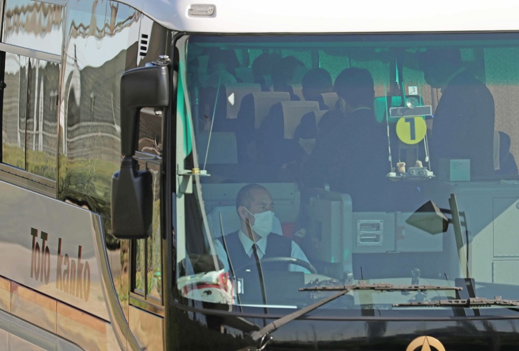 圖為1月30日第二班接載日本僑民從中國武漢市返回日本的包機在東京羽田機場降落後，一輛巴士載着從武漢市返回的僑民。（AFP）