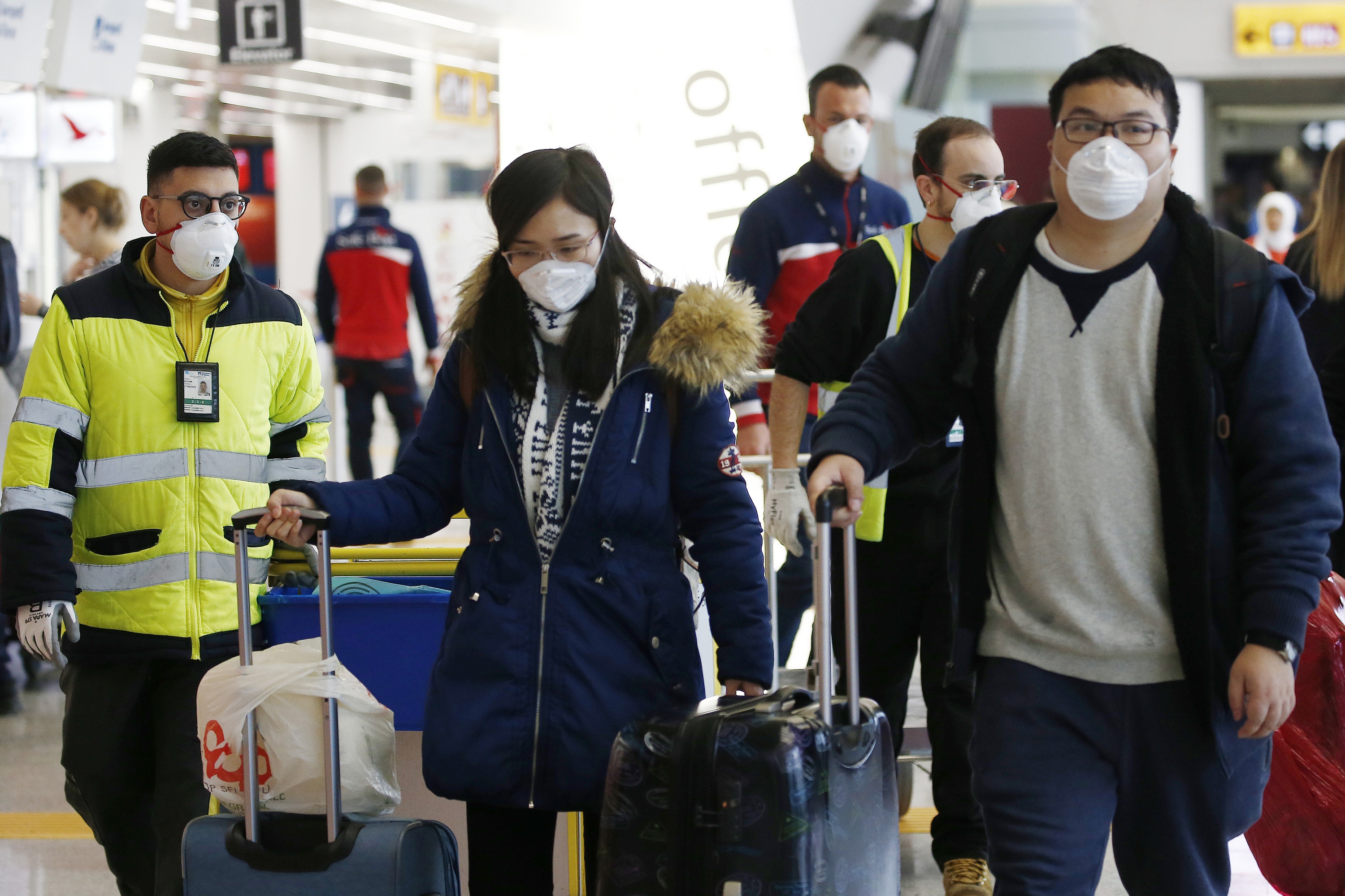 意大利出現兩宗確診病例。在羅馬的機場，職員和旅客都戴上口罩。（AP）