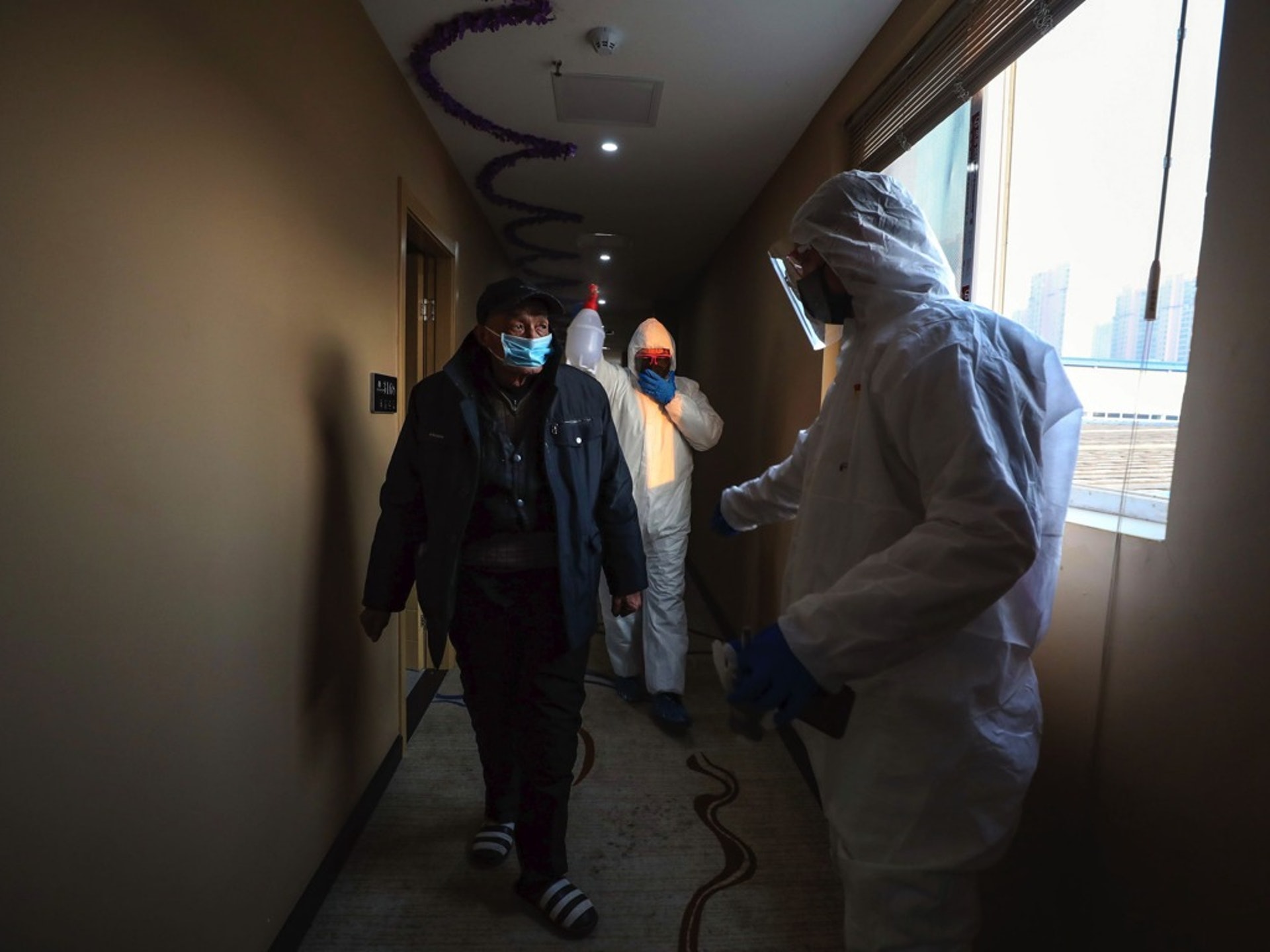 2020年2月3日,在中國中部湖北省武漢市,穿着防護服的工作人員在一家酒店為被隔離的病人分發食物。(AP) 2020年2月3日,在中國中部湖北省武漢市,穿着防護服的工作人員在一家酒店為被隔離的病人分發食物。(AP)