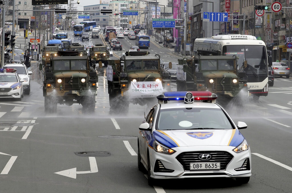 圖為2月29日韓國軍方出動軍車，在大邱市路面噴灑消毒劑。（AP）