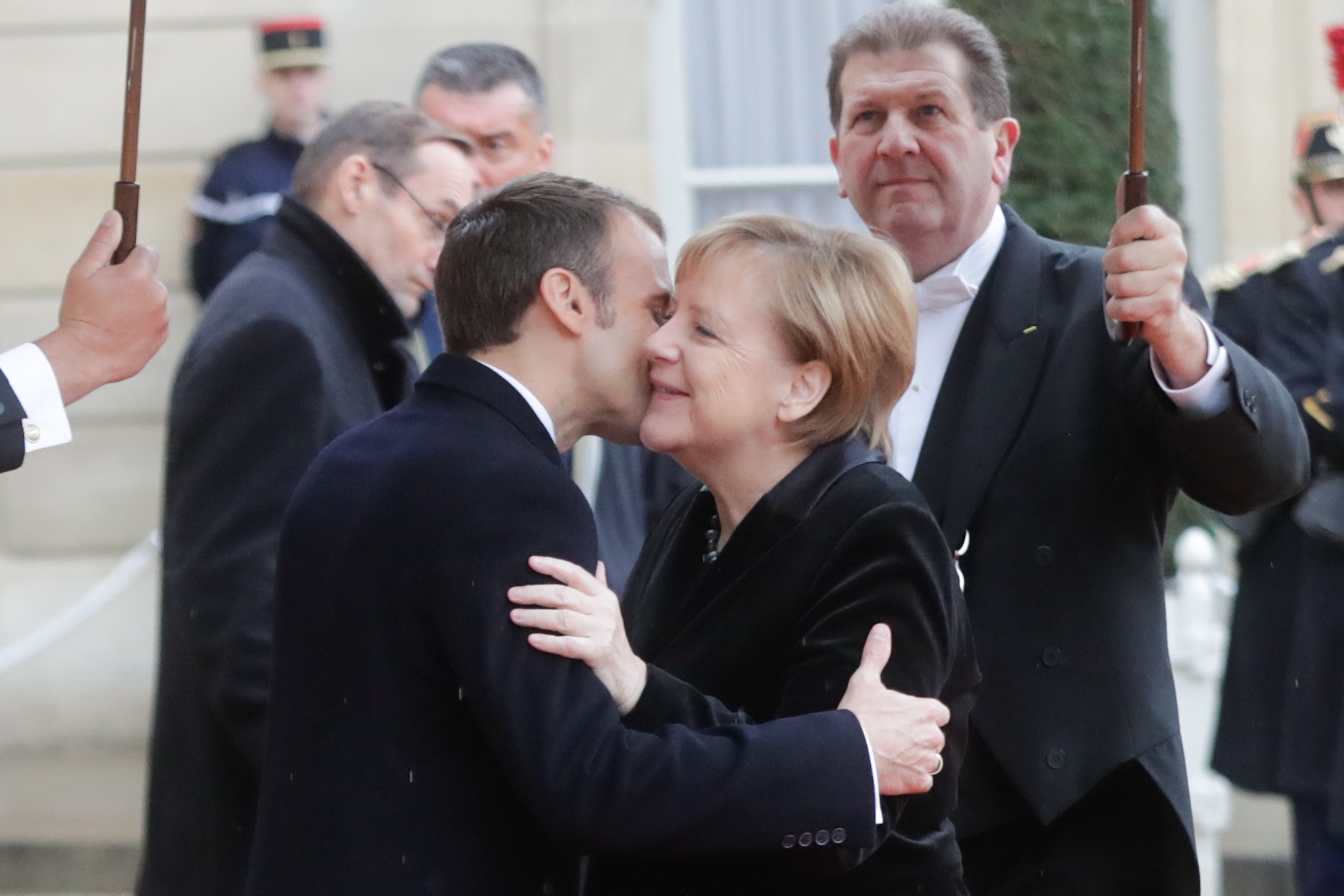 法國總統馬克龍與德國總理默克爾，親吻臉頰的打招呼樣子。（Getty）