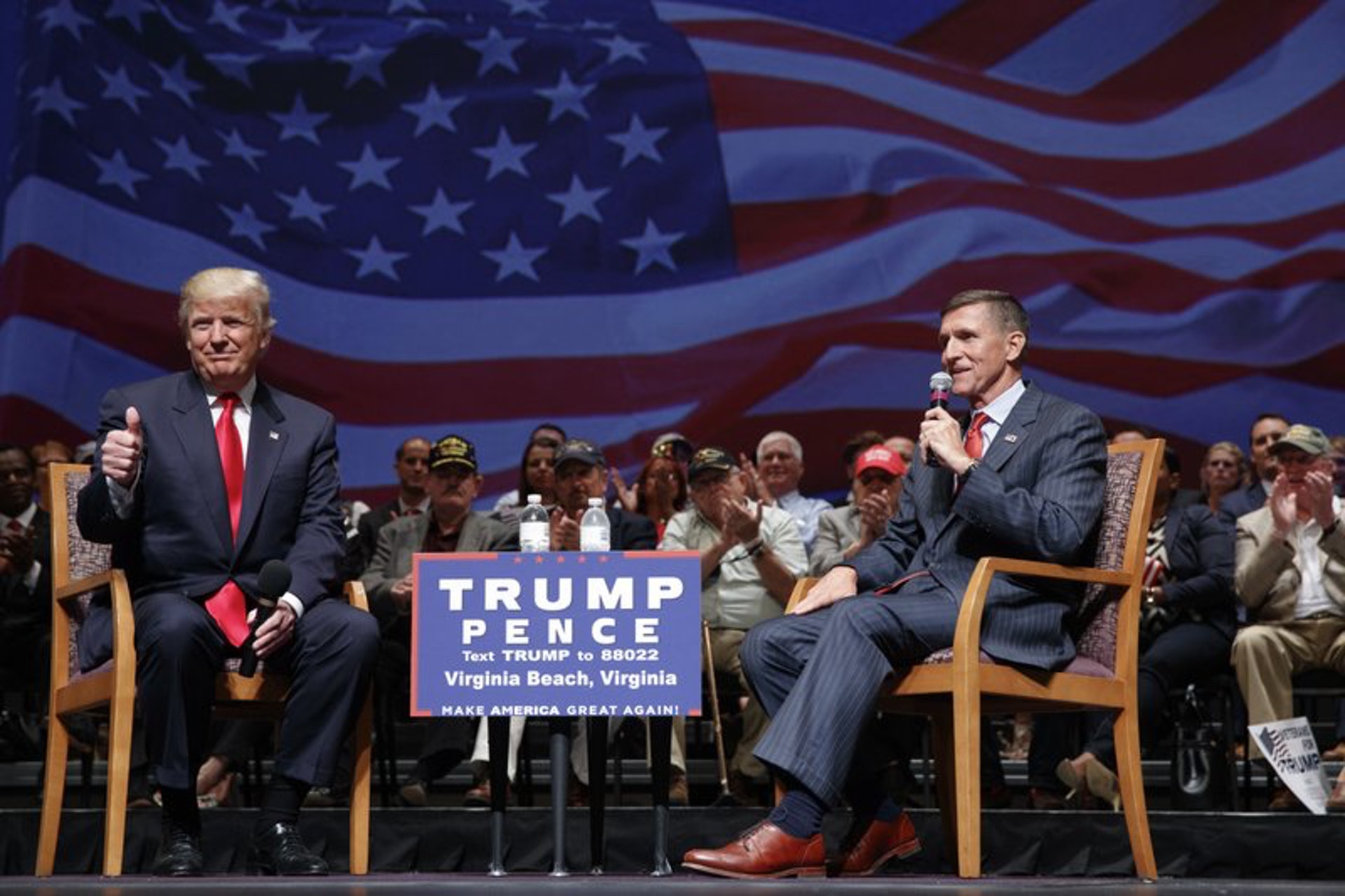 2016年9月，時任共和黨總統候選人特朗普與退役的陸軍中將弗林在維珍尼亞沙灘市政廳裏演講。特朗普對觀眾豎起大拇指。（AP）