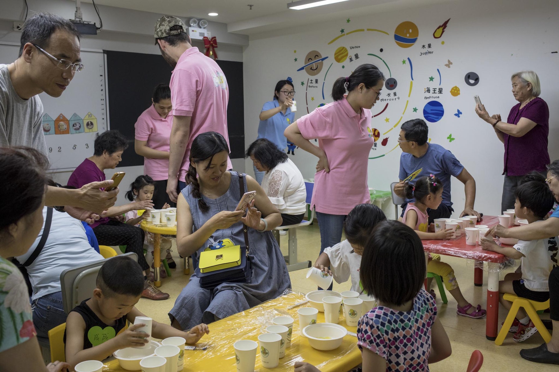 2018年5月26日,北京一家幼小銜接教育機構的活動室內,孩子們和家長在老師的指導下進行蛋糕杯的製作。(視覺中國) 2018年5月26日,北京一家幼小銜接教育機構的活動室內,孩子們和家長在老師的指導下進行蛋糕杯的製作。(視覺中國)