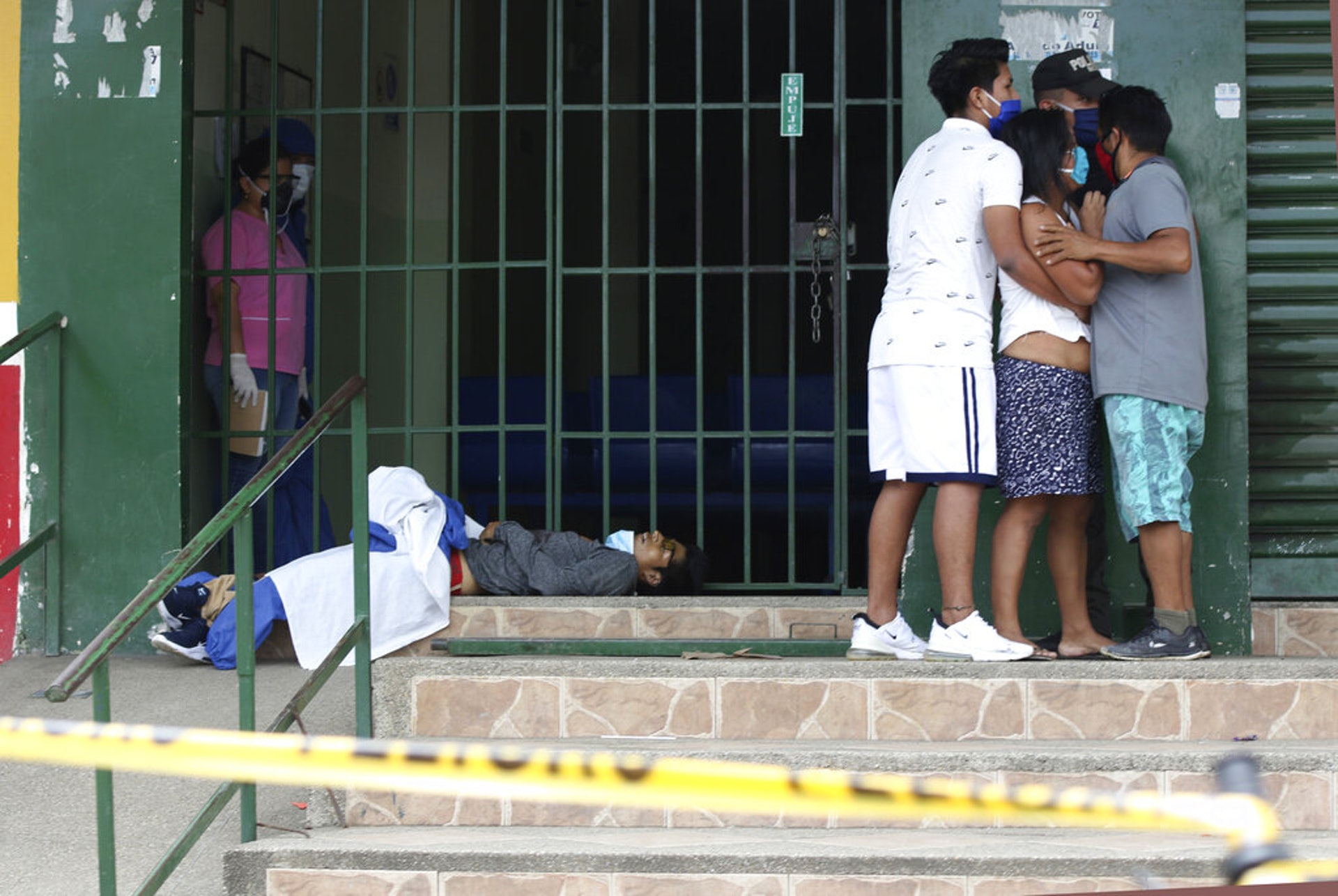 厄瓜多爾新冠肺炎疫情：幾名戴着口罩的人2020年4月16日在瓜亞基爾一間診所前擠在一起，當時這間診所沒有開門。（AP）