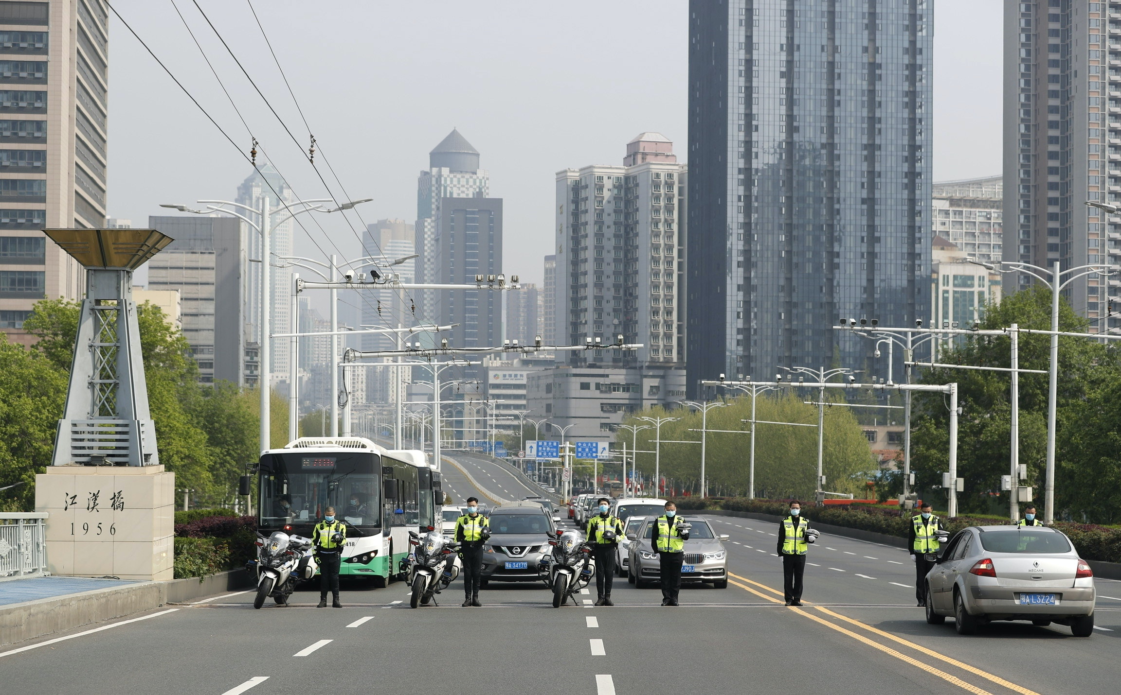 4月4日，在武漢市江漢一橋，交警和市民停車鳴笛默哀。（新華社）