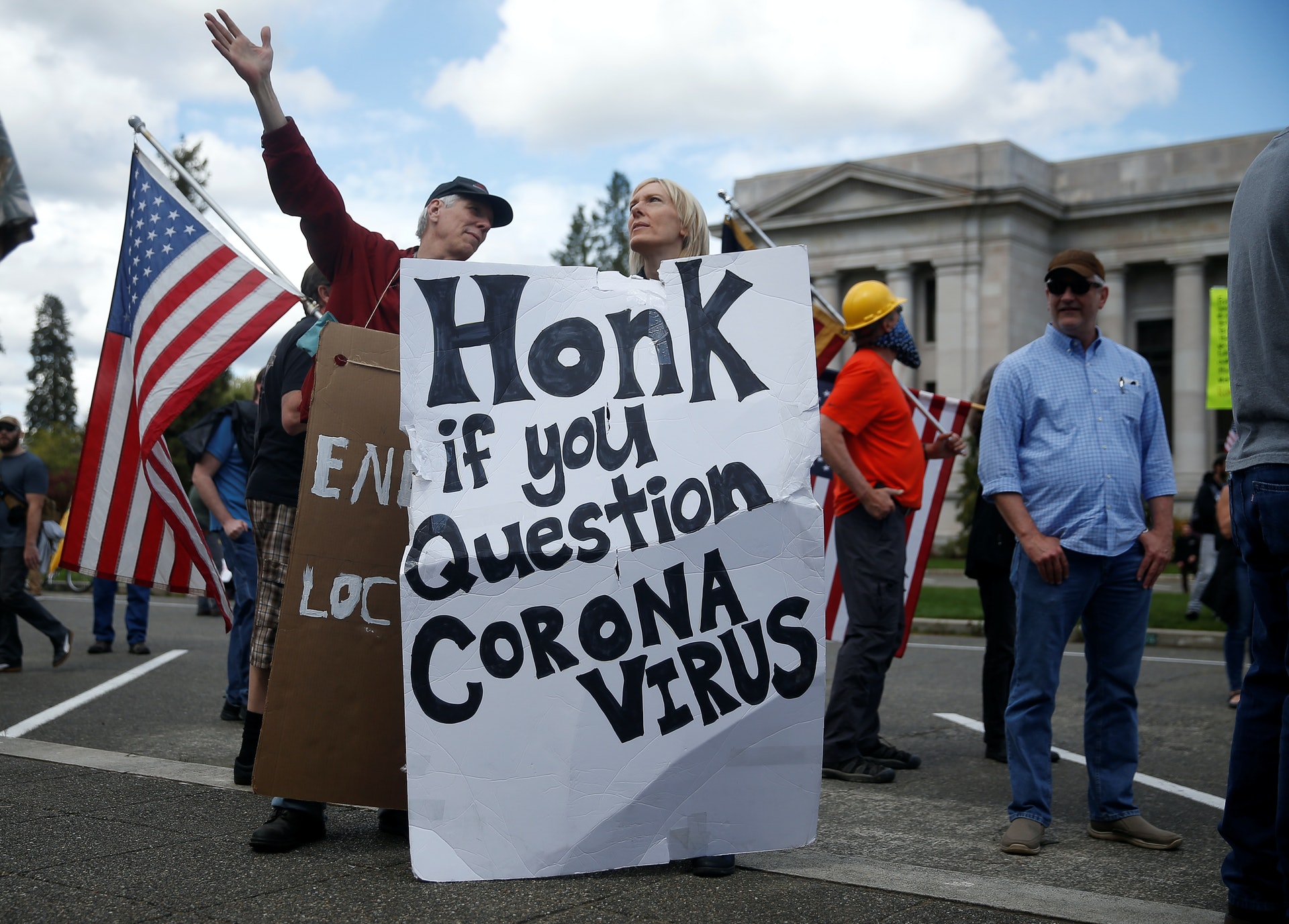 示威者拉起寫着「質疑冠狀病毒的請響咹」的橫額。（路透社）